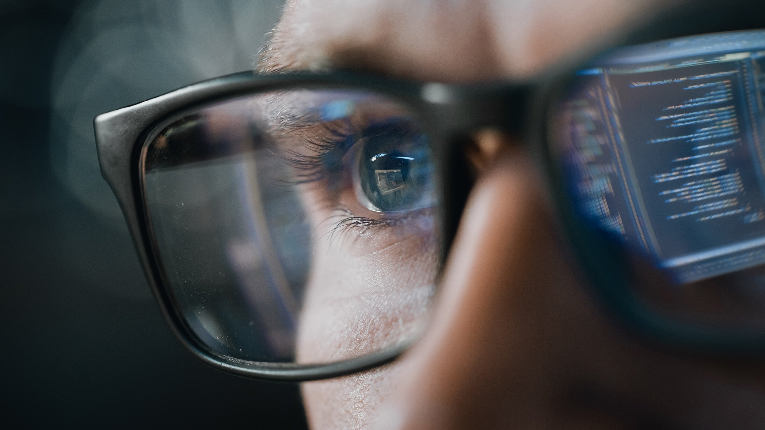 Digital information reflects in the lens of an investor’s glasses—representing research of  the fund details of Invesco QQQ ETF.