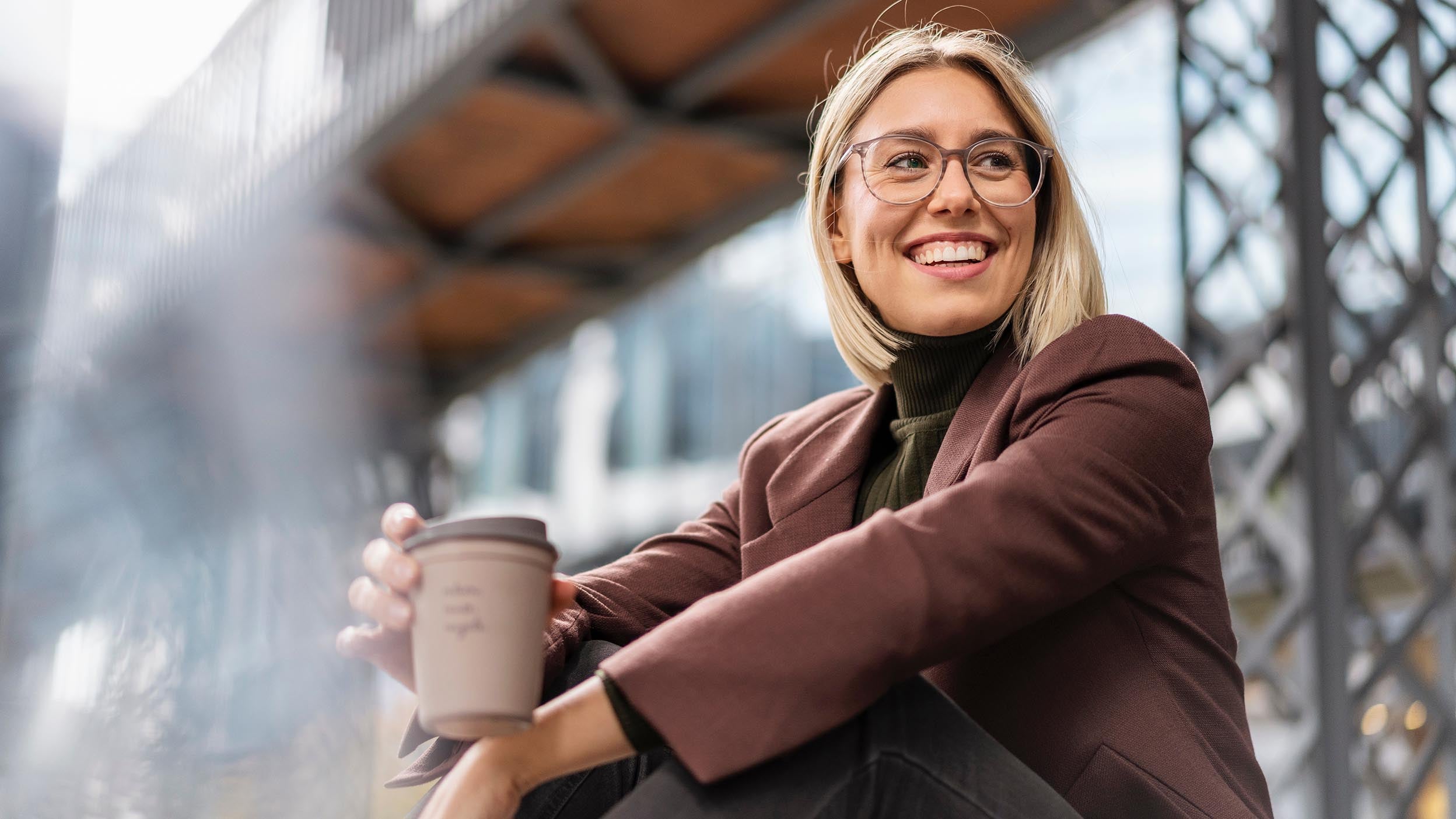 A young women enjoying a cup of coffee illustrates the way innovation is thriving in unexpected places—including some of the underlying holdings of Invesco QQQ ETF.