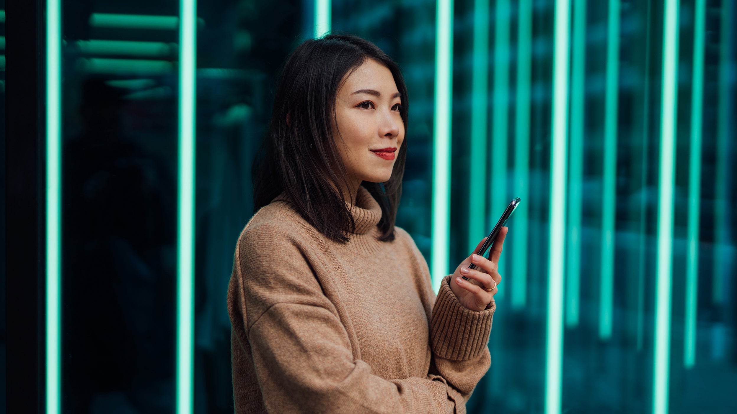 A smiling woman is pondering the Invesco QQQ ETF companies that are helping build and transform the blockchain ecosystem.