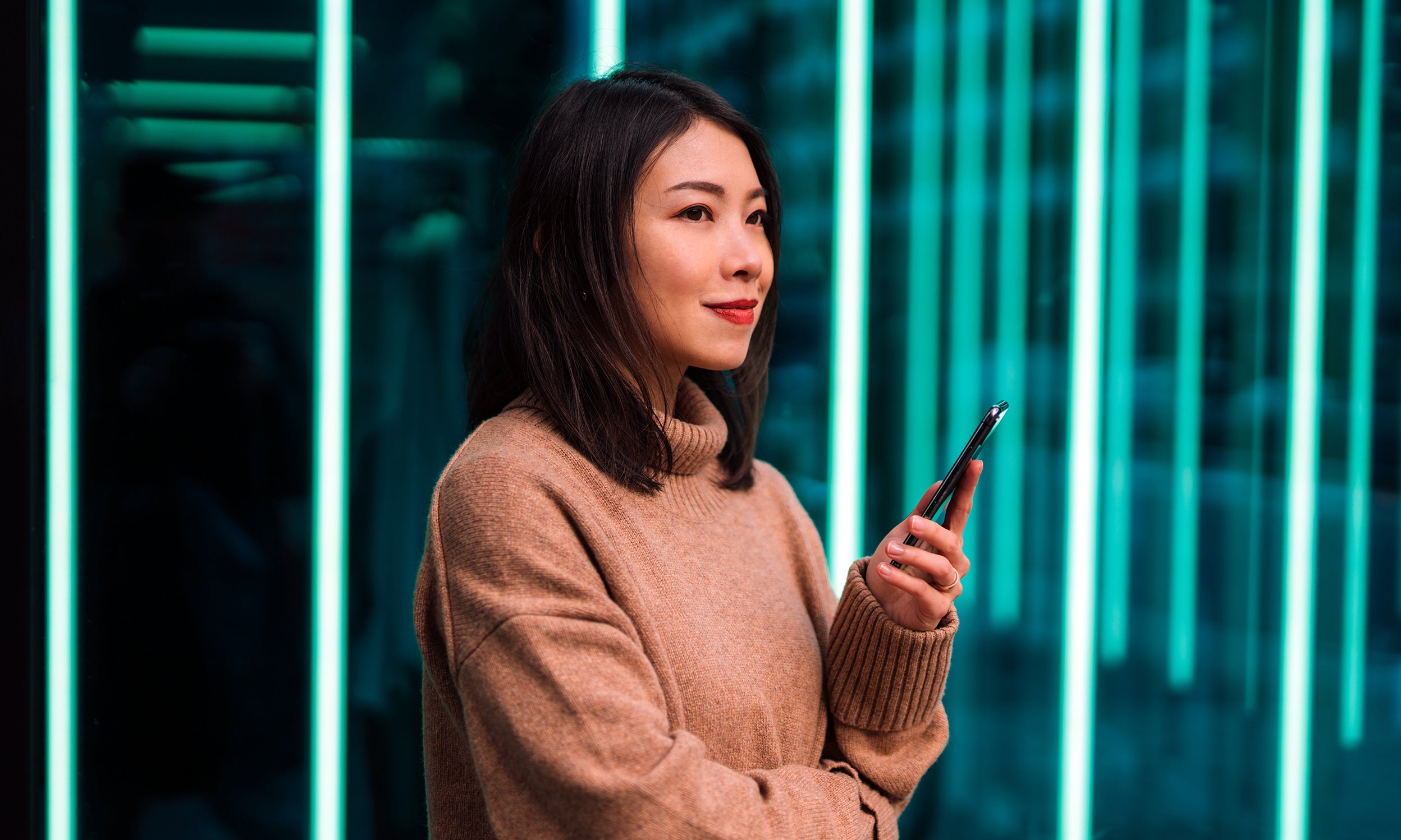 A smiling woman is pondering the Invesco QQQ ETF companies that are helping build and transform the blockchain ecosystem.