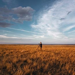 A%20photographer%20working%20alone%20in%20a%20grassy%20field%20at%20sunset%20contemplates%20his%20surroundings%20and%20the%20current%20state%20of%20the%20market.