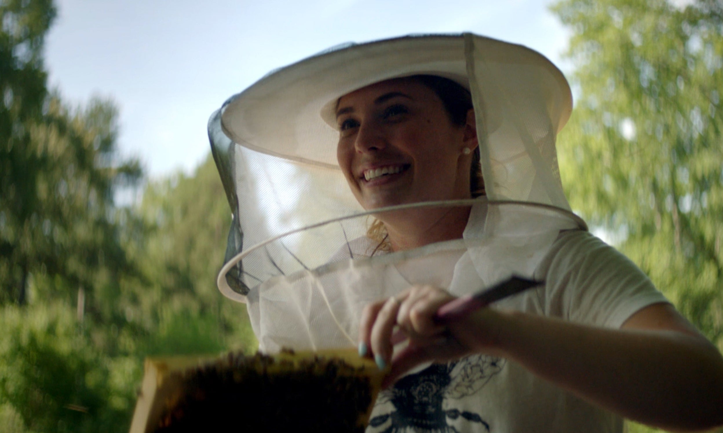 Bee Downtown CEO checking an artificial bee hive. Bee Downtown is featured in Invesco QQQ's Innovation Now series.