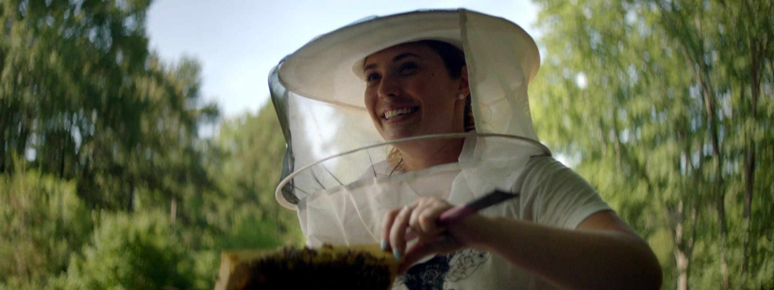 Bee Downtown CEO checking an artificial bee hive. Bee Downtown is featured in Invesco QQQ's Innovation Now series.