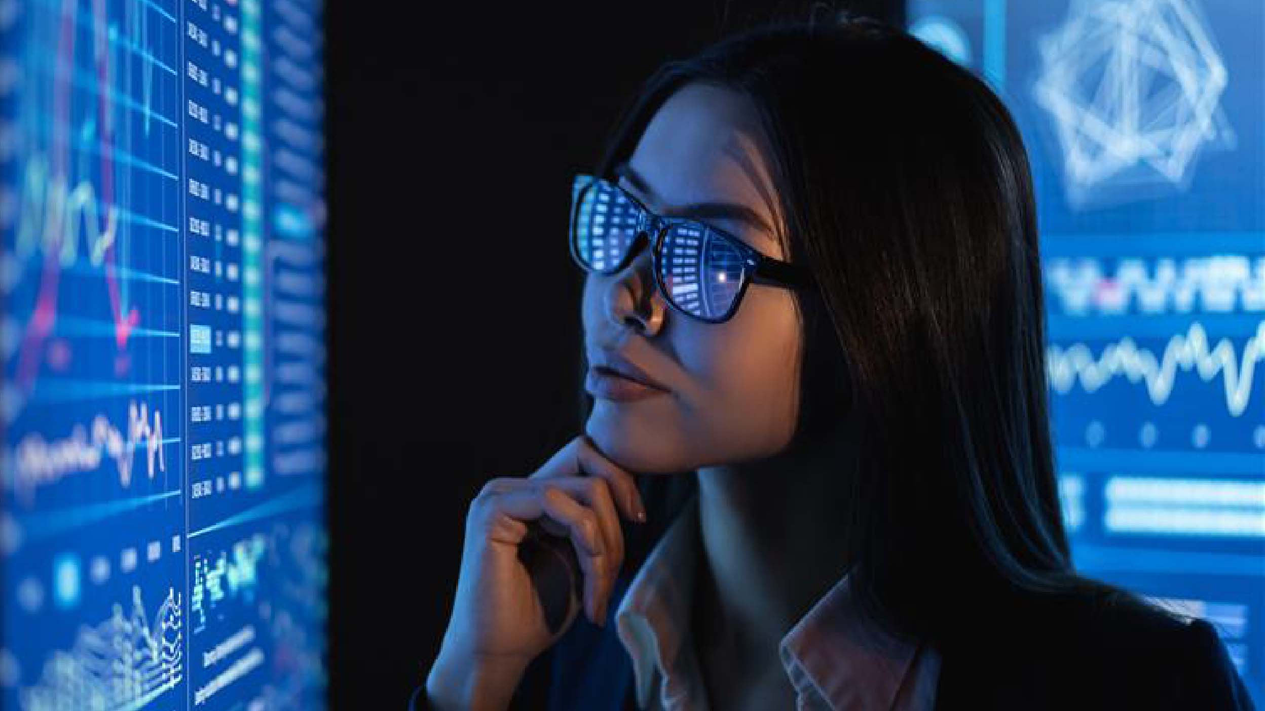The business woman looks on a large blue screen with chart