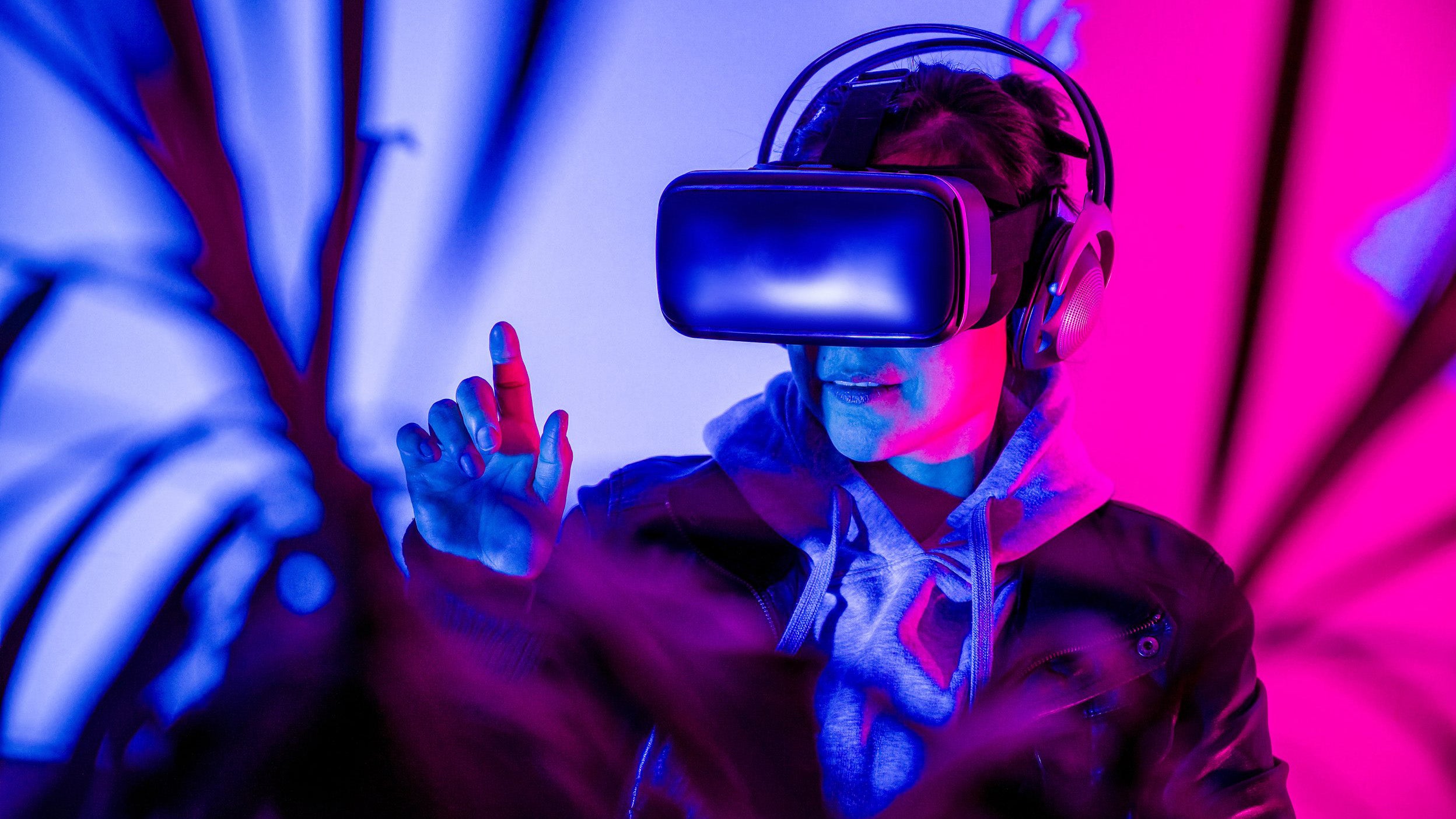 Woman interacting in virtual reality with VR glasses, enjoying the metaverse.