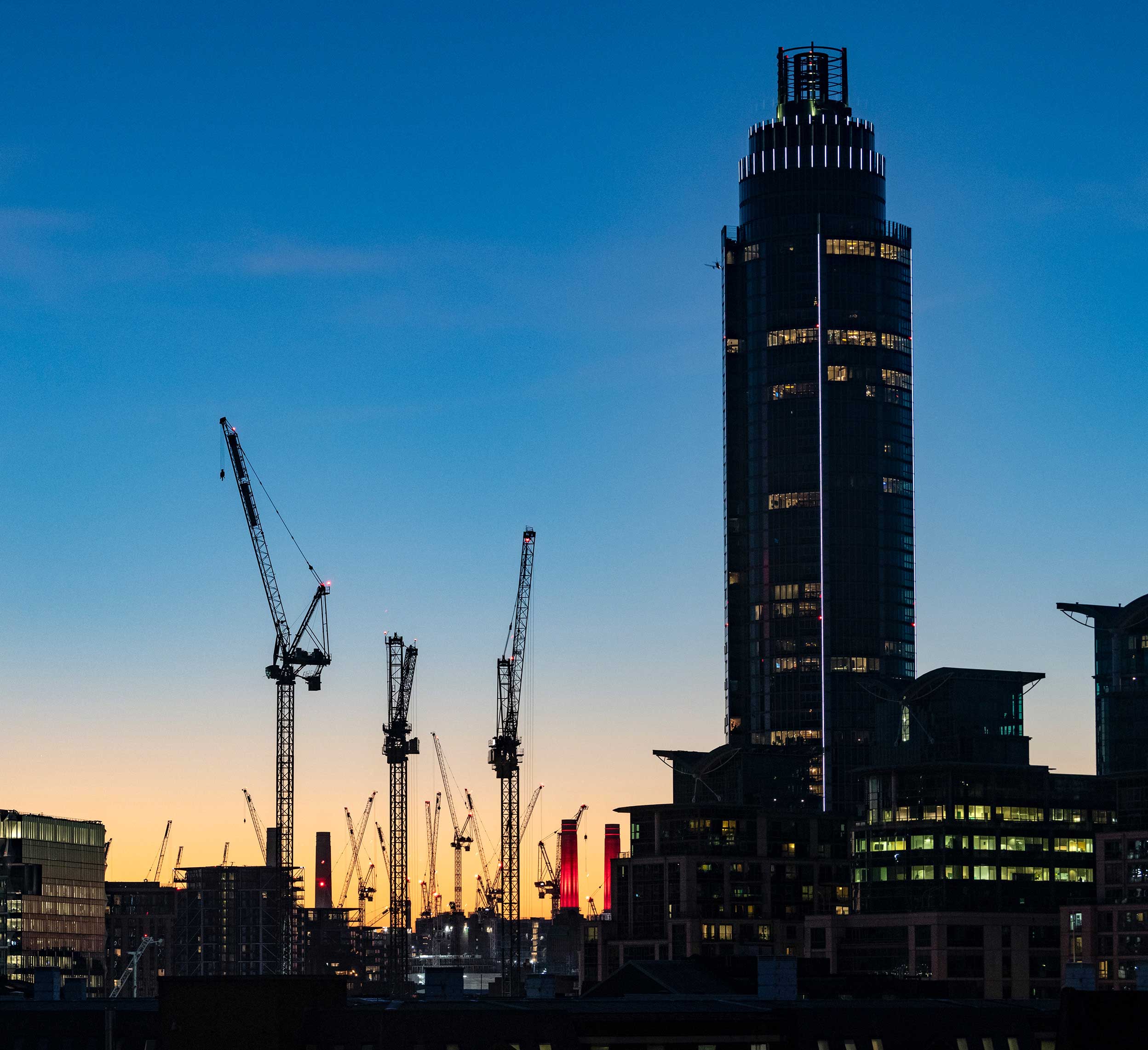City construction cranes at dusk
