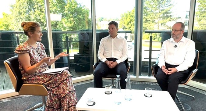 UK Equity Fund Managers James Goldstone and Ciaran Mallon sit with Georgina Millar in a meeting room