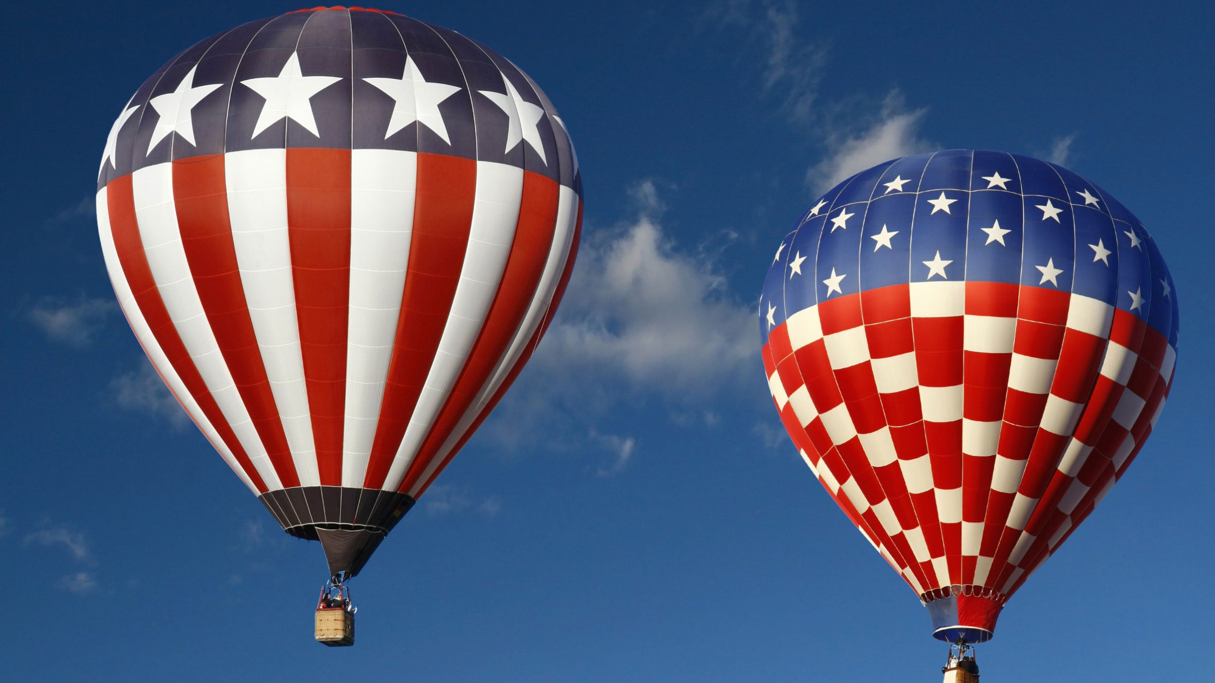 Two hot air balloons in American flags in the air