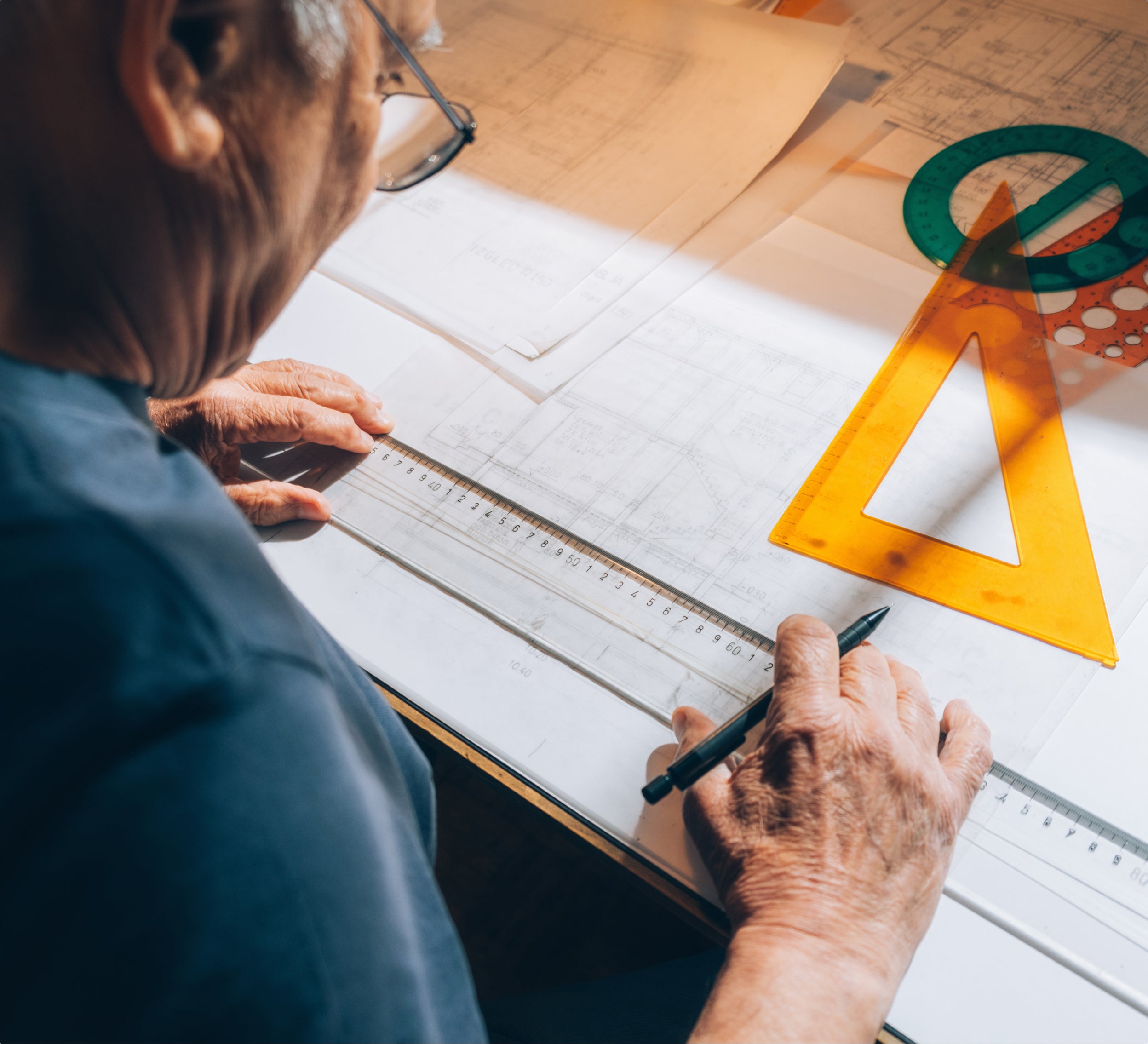Person using drafting tools on a technical drawing