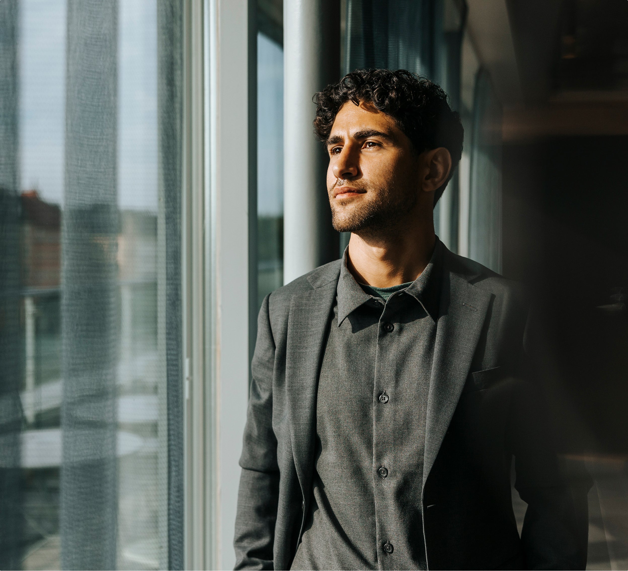 Person standing by office windows in business attire