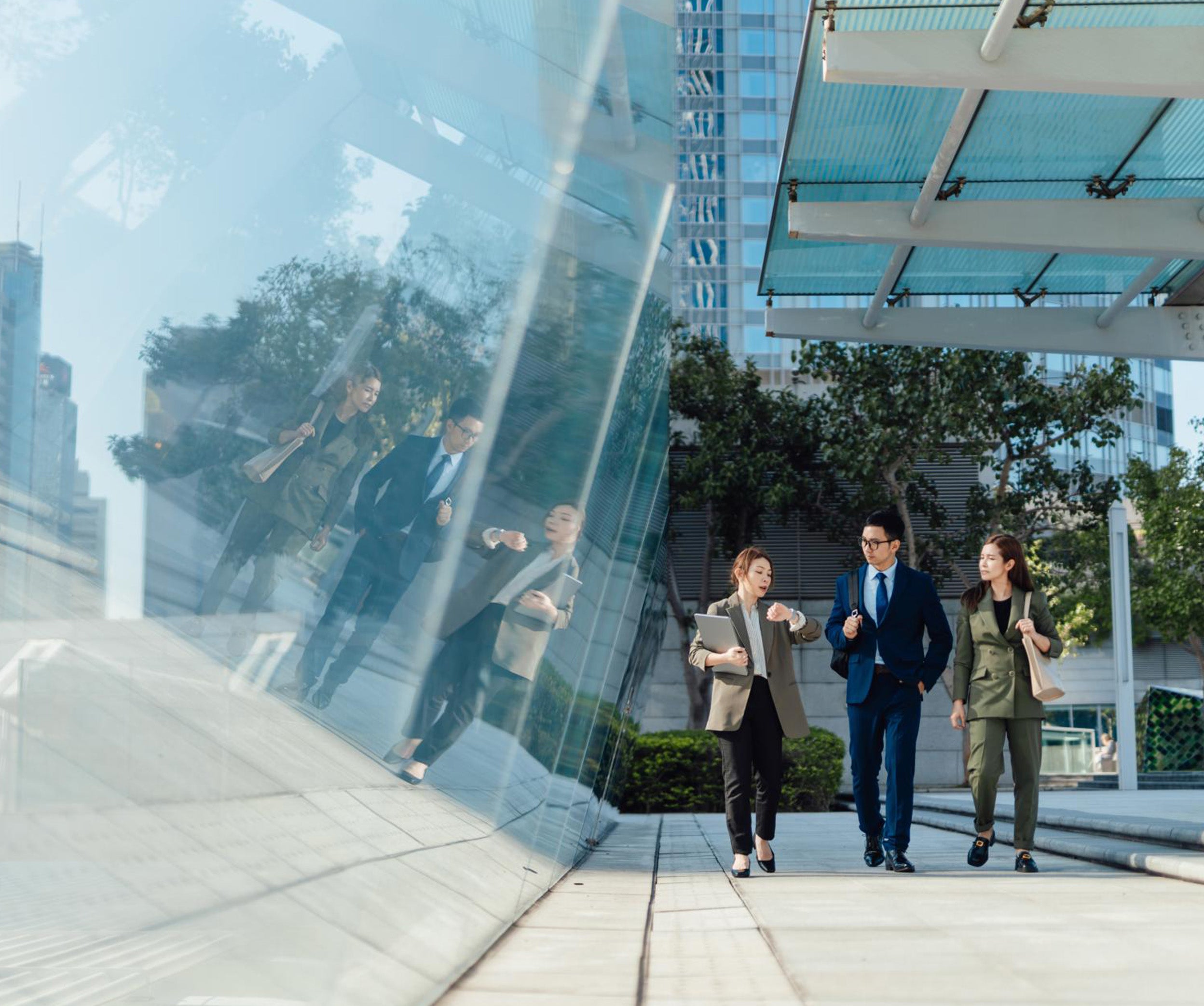 Three people walking outside a modern office building