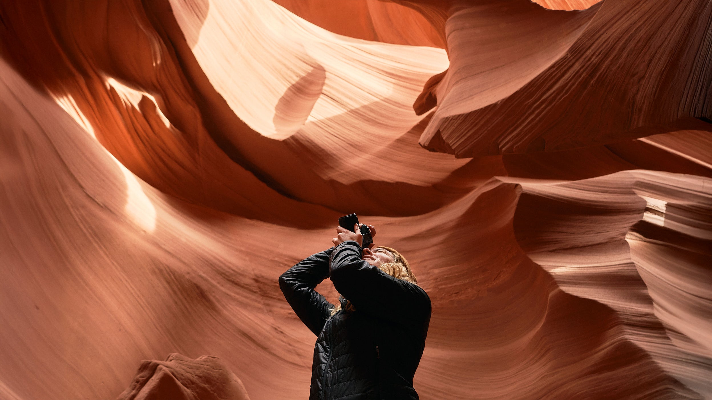 Woman in a cave taking a photo