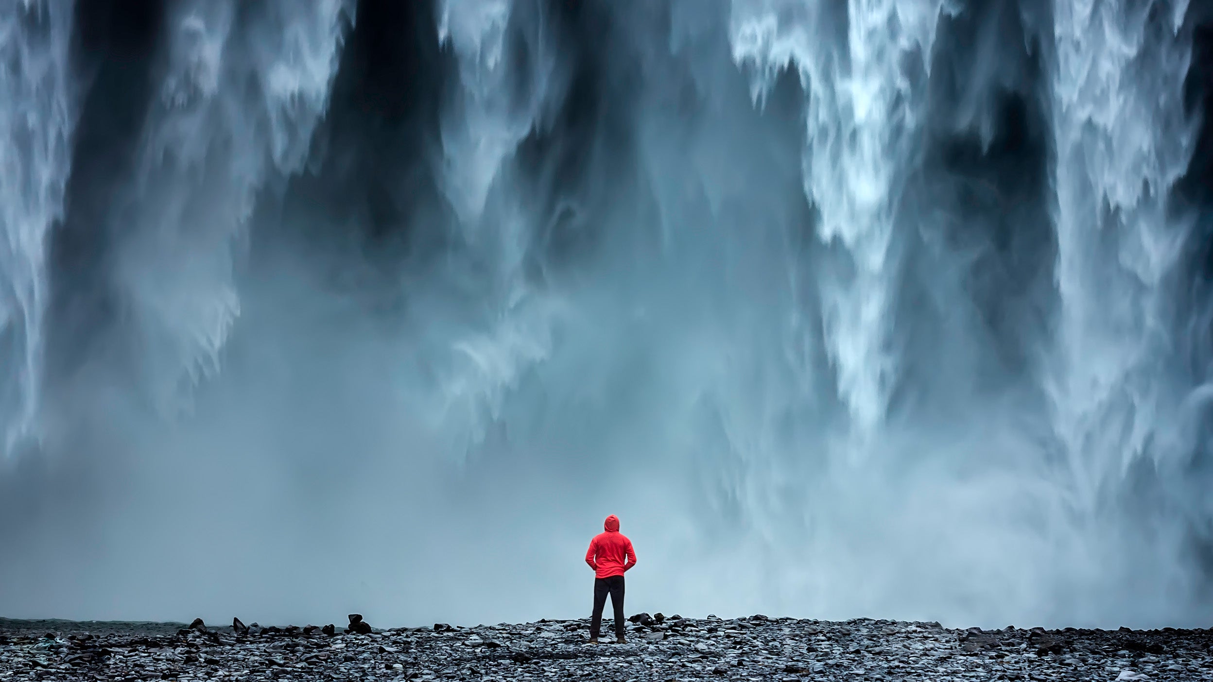 Woman standing under a waterfall