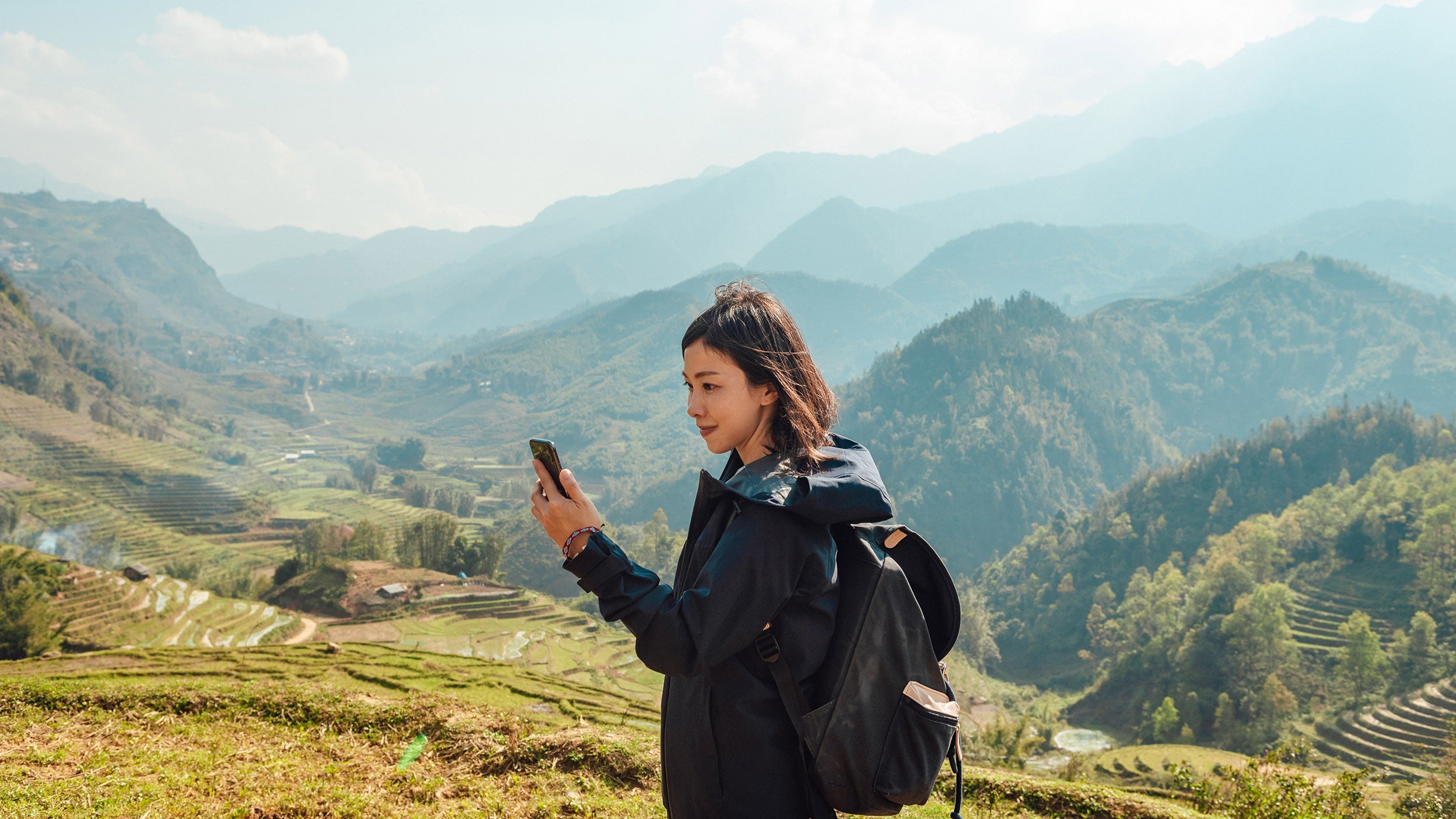Person taking a photo in a mountain valley