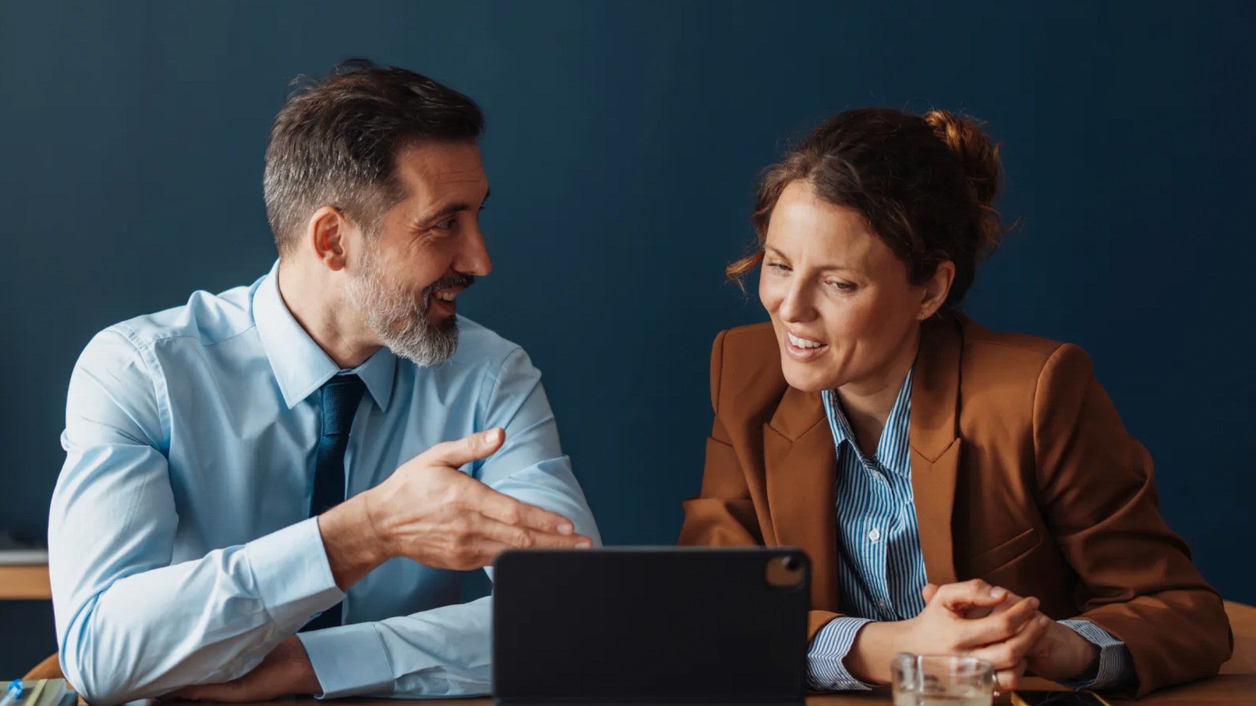 Two people reviewing information on a tablet