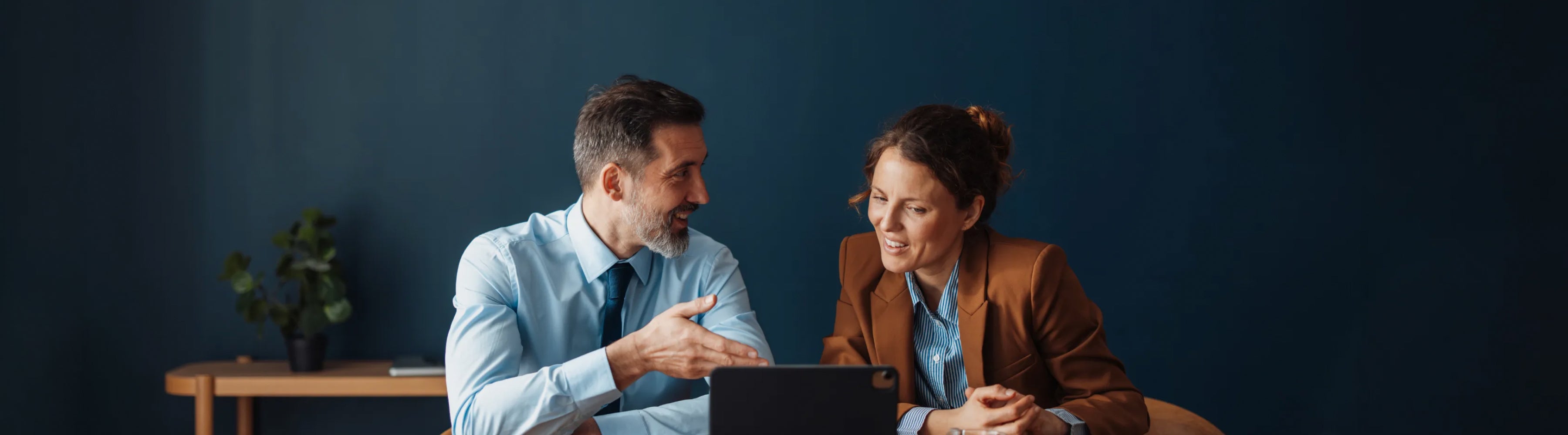 Two people reviewing information on a tablet.