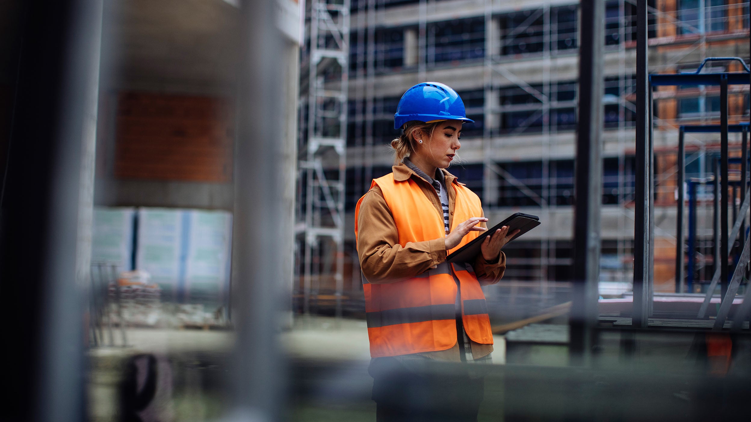 Young female worker using her digital tablet at a construction site