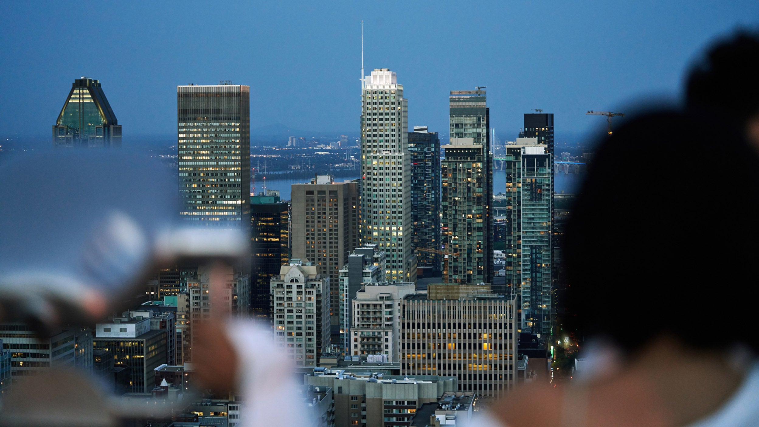  City skyline at dusk with illuminated skyscrapers.