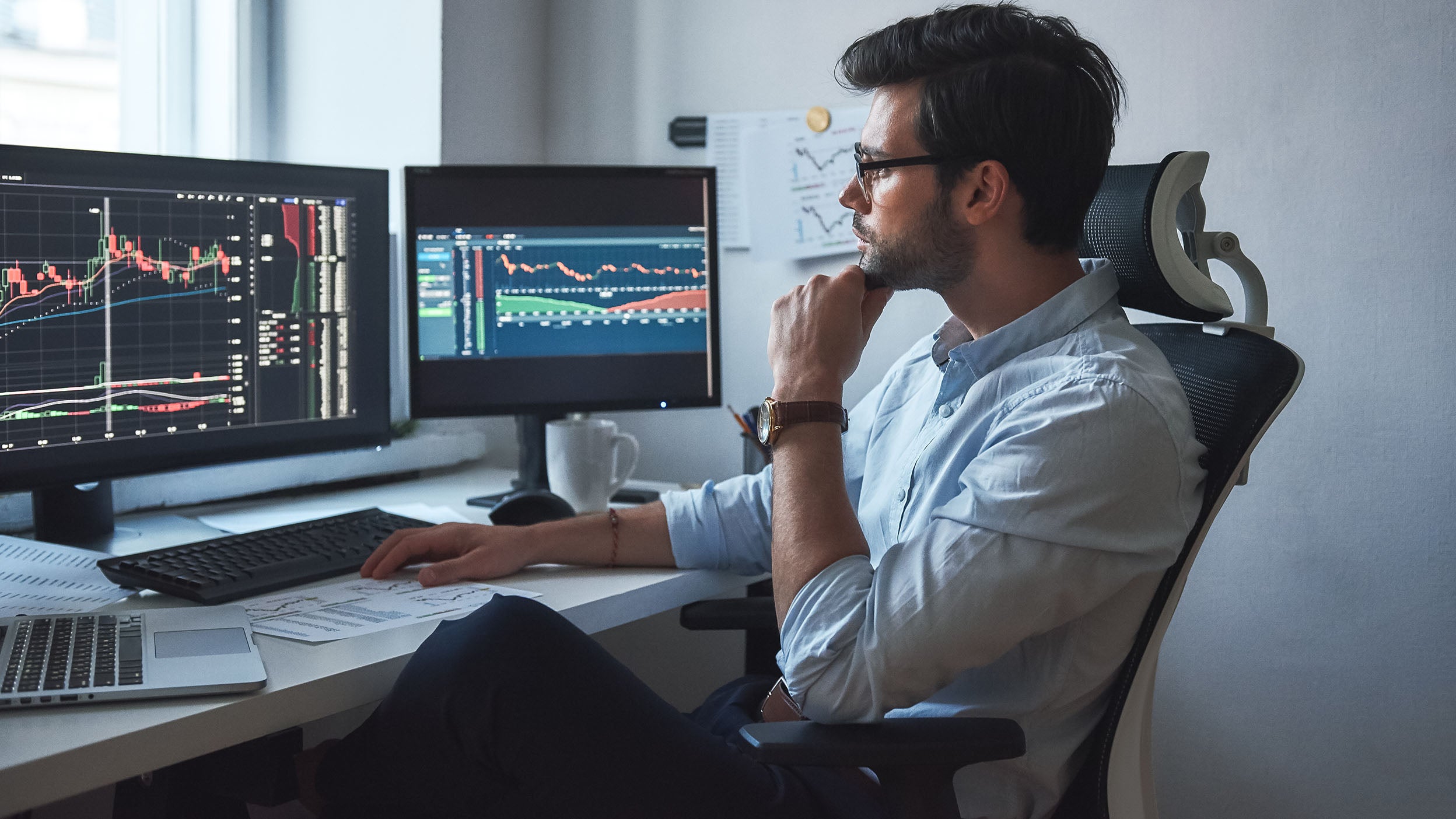 A man looks at charts on his computer.