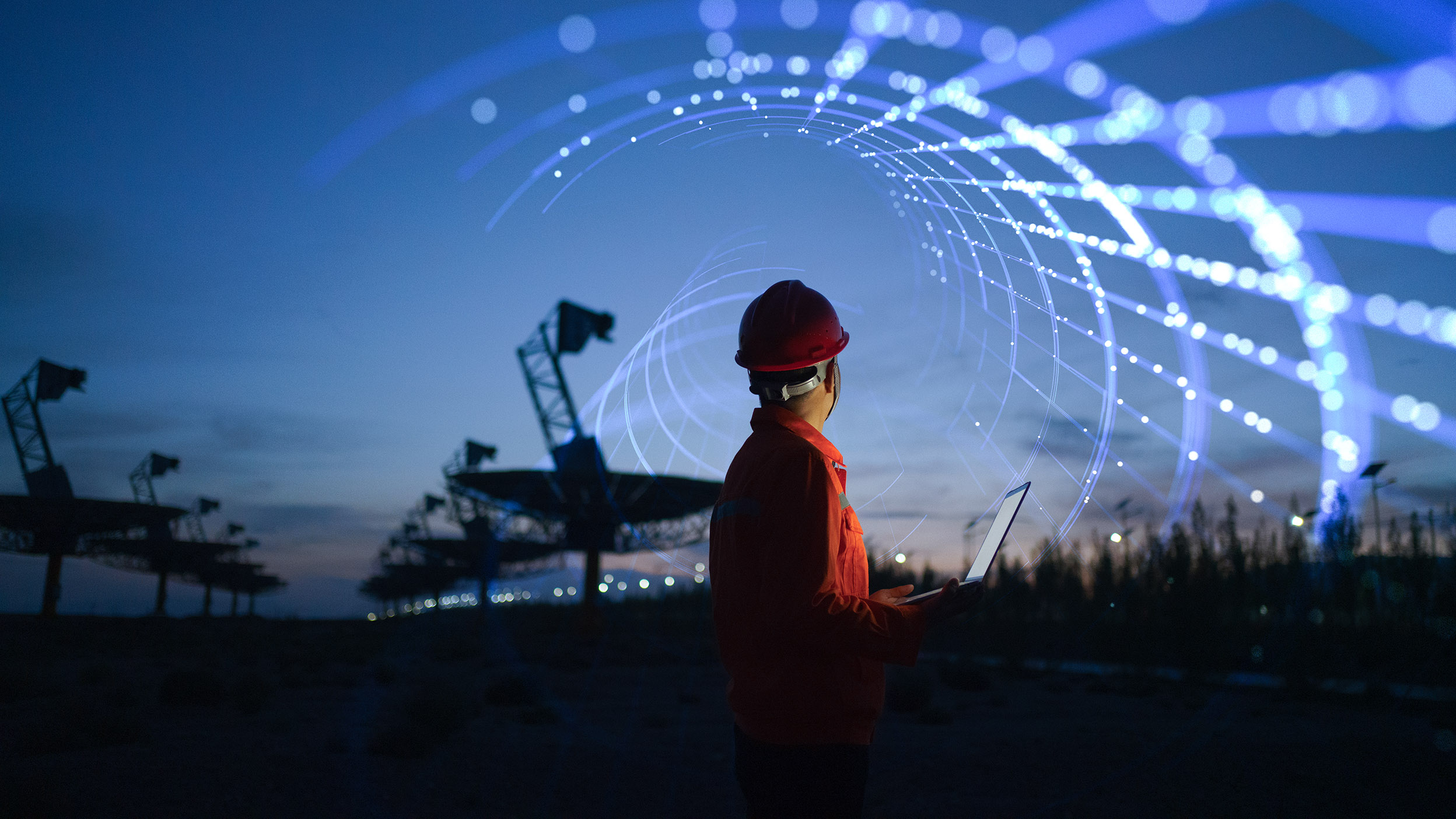 Electricity worker using laptop at solar thermal power plant