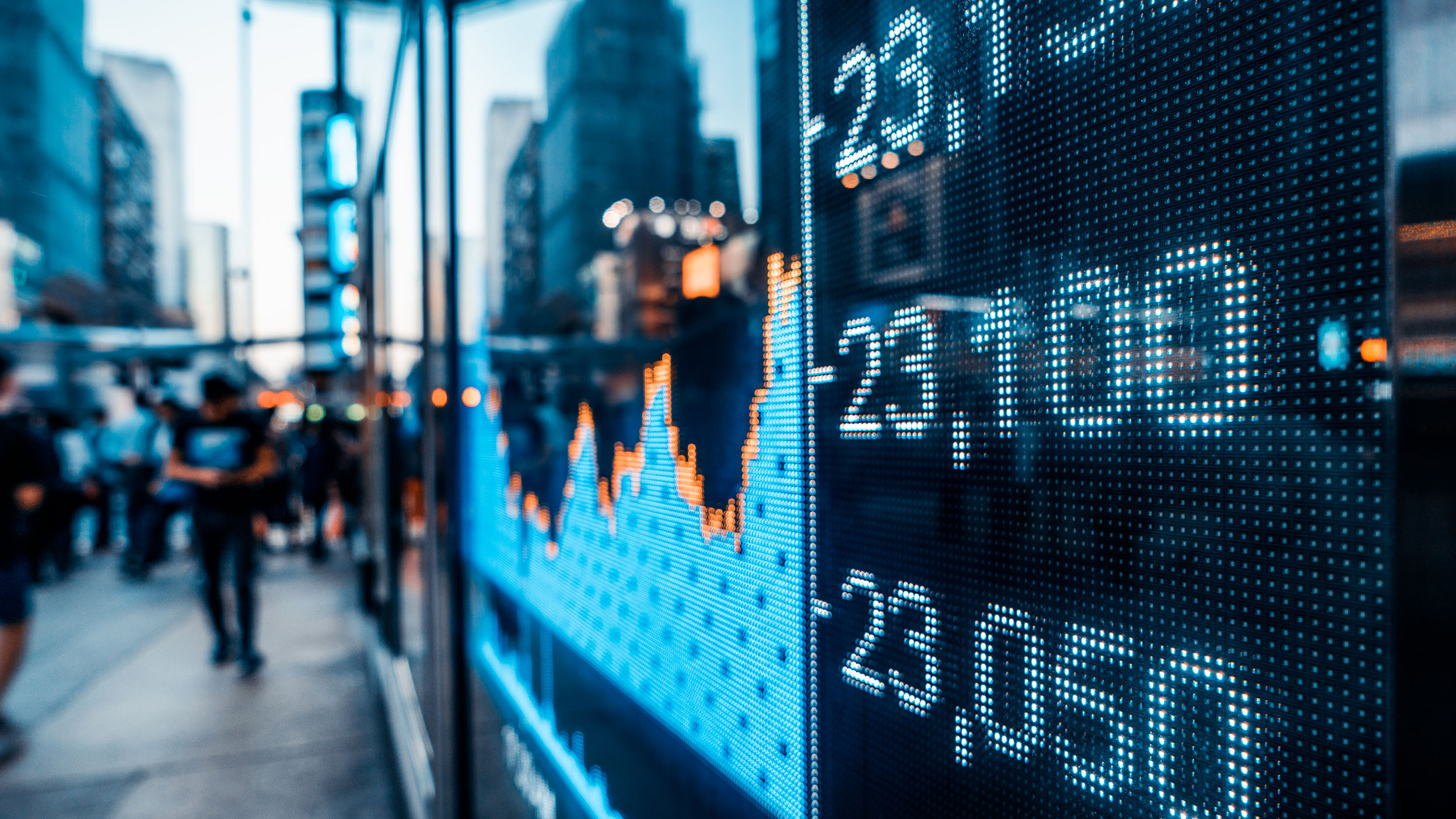 Financial stock market numbers and city light reflection on the exterior of a building.