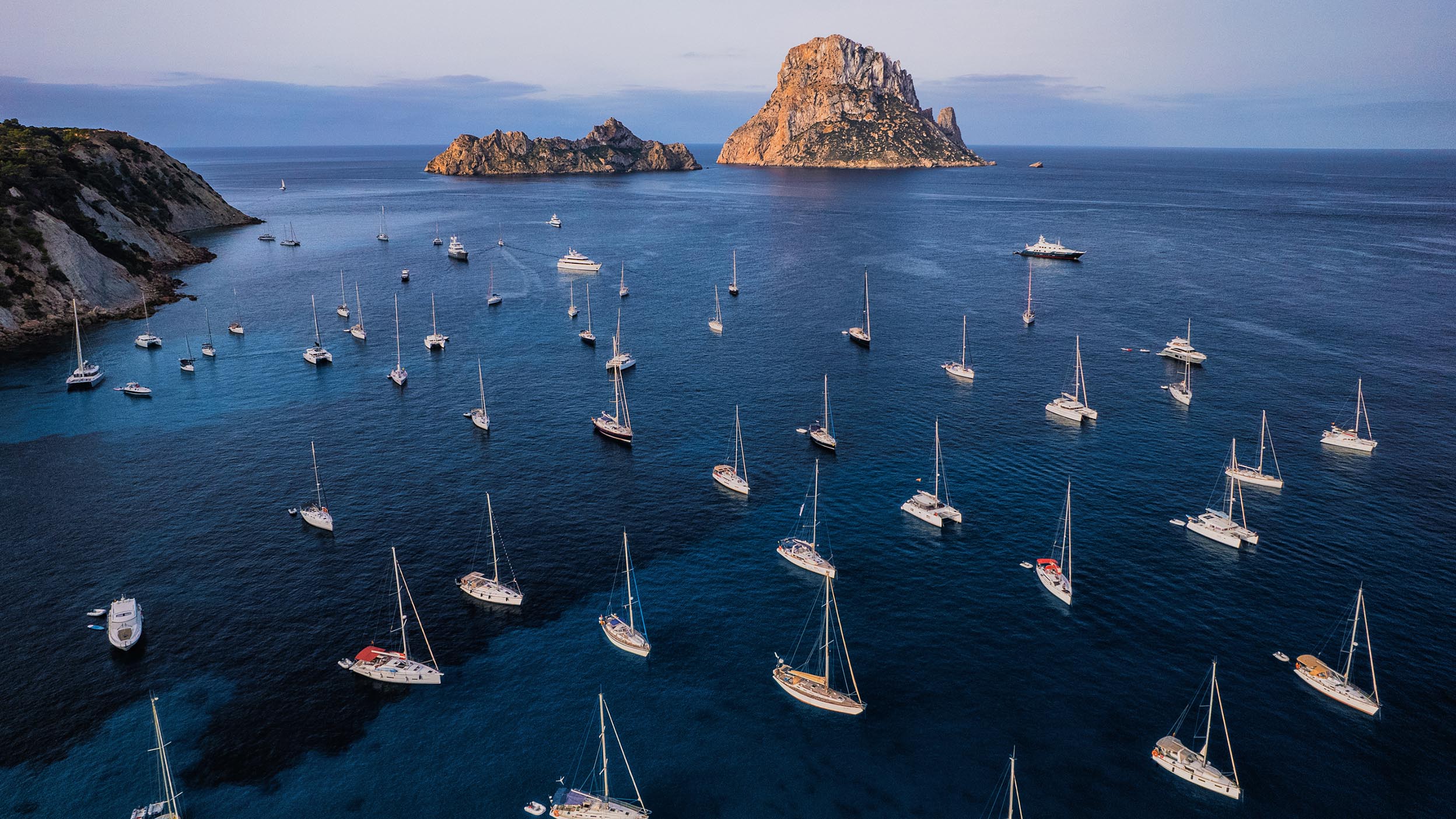 Lot of boats are in a see from bird eye view.
