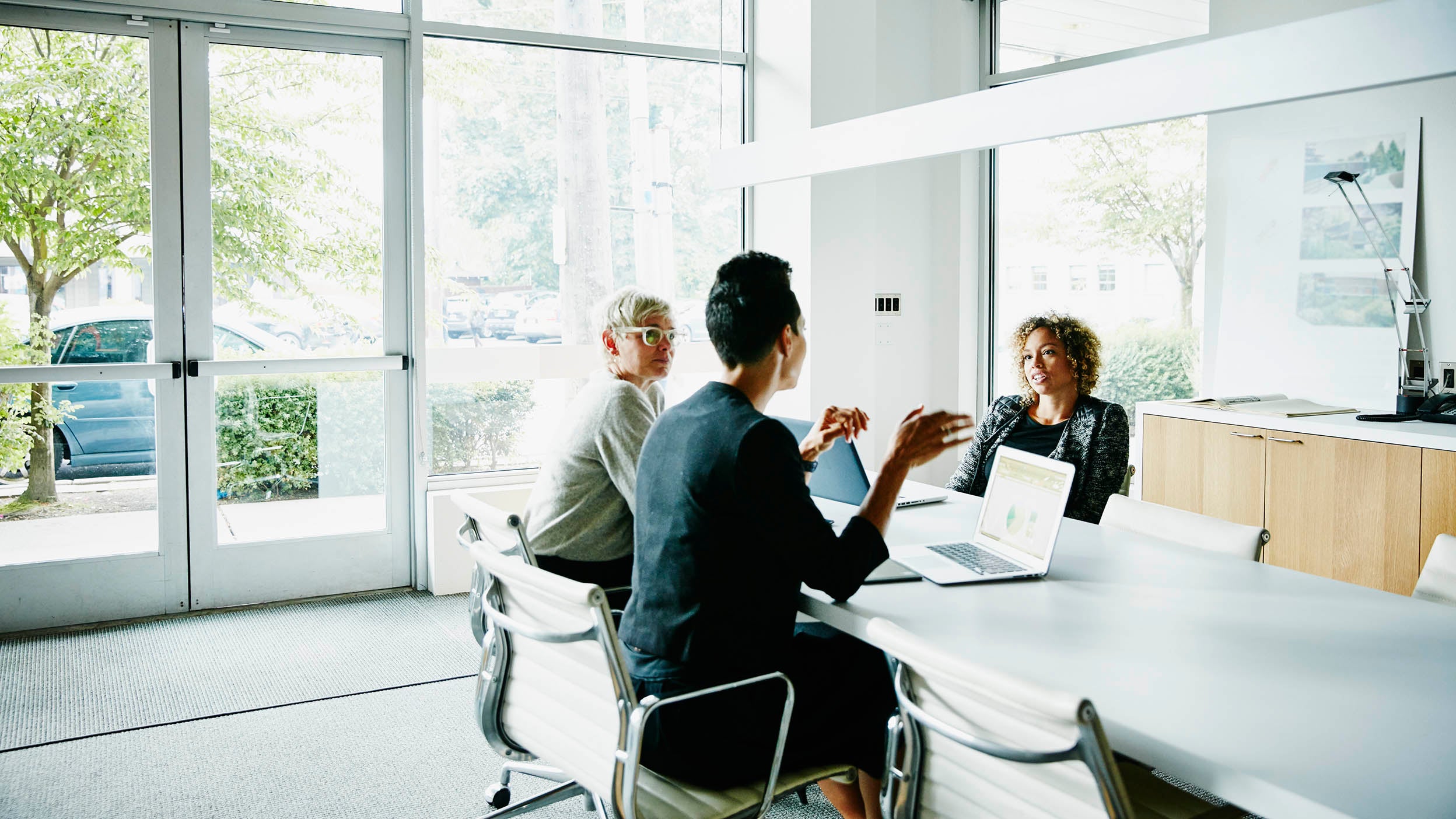 Three employees discussing in the office room.