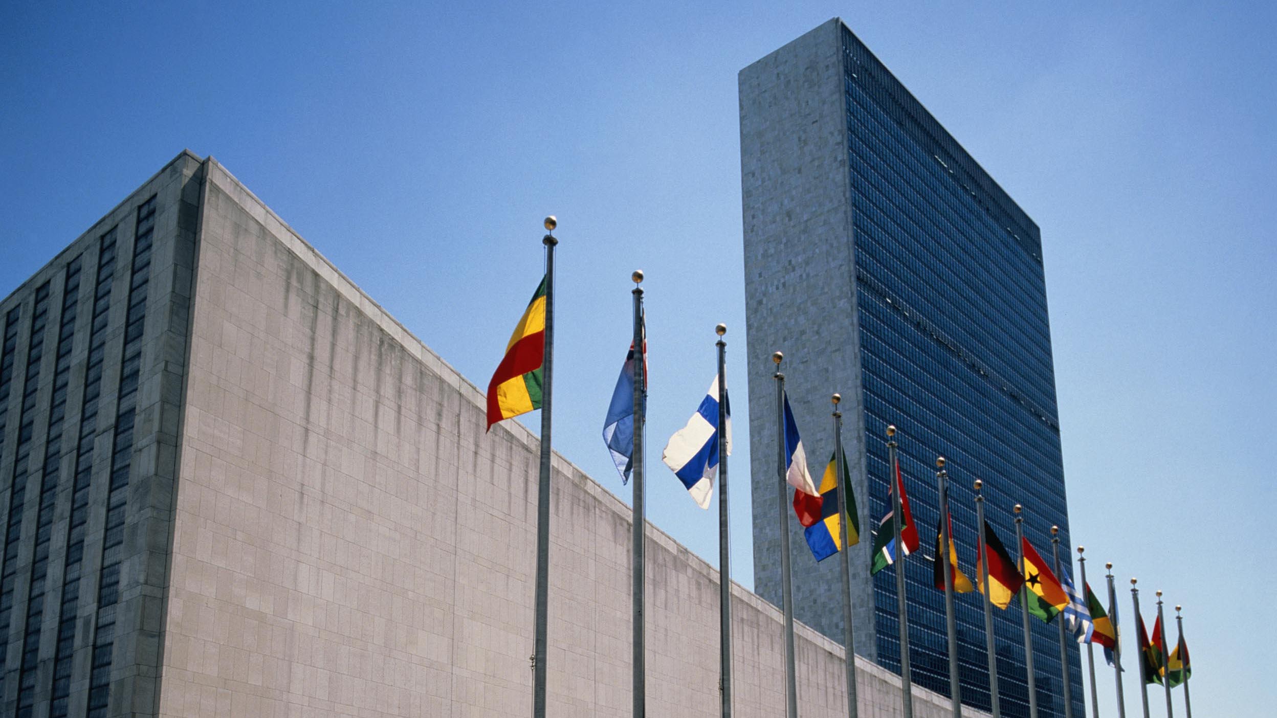 Flags fly in front of the United Nations building.