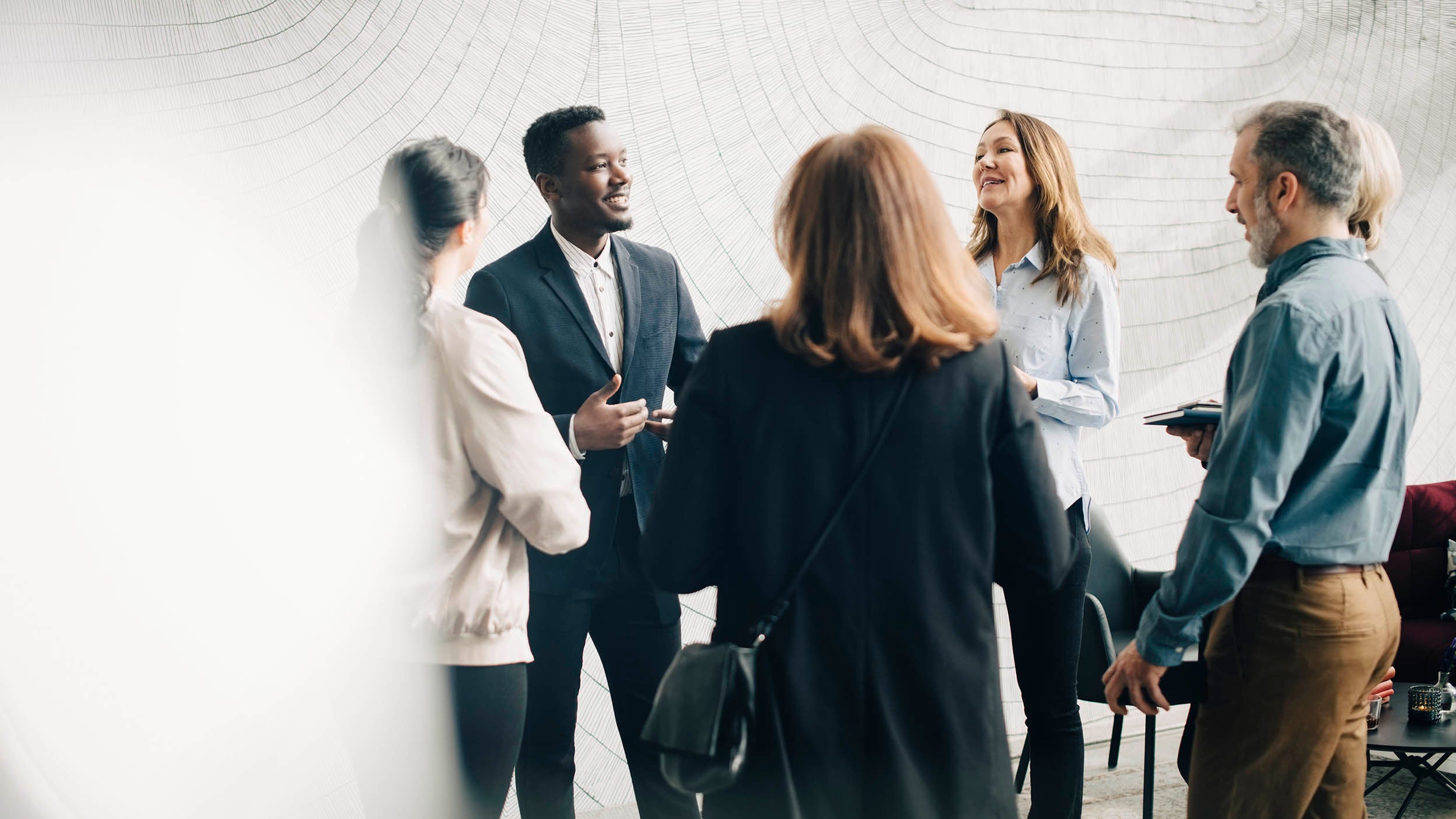 Colleagues standing in a circle chatting with one another.