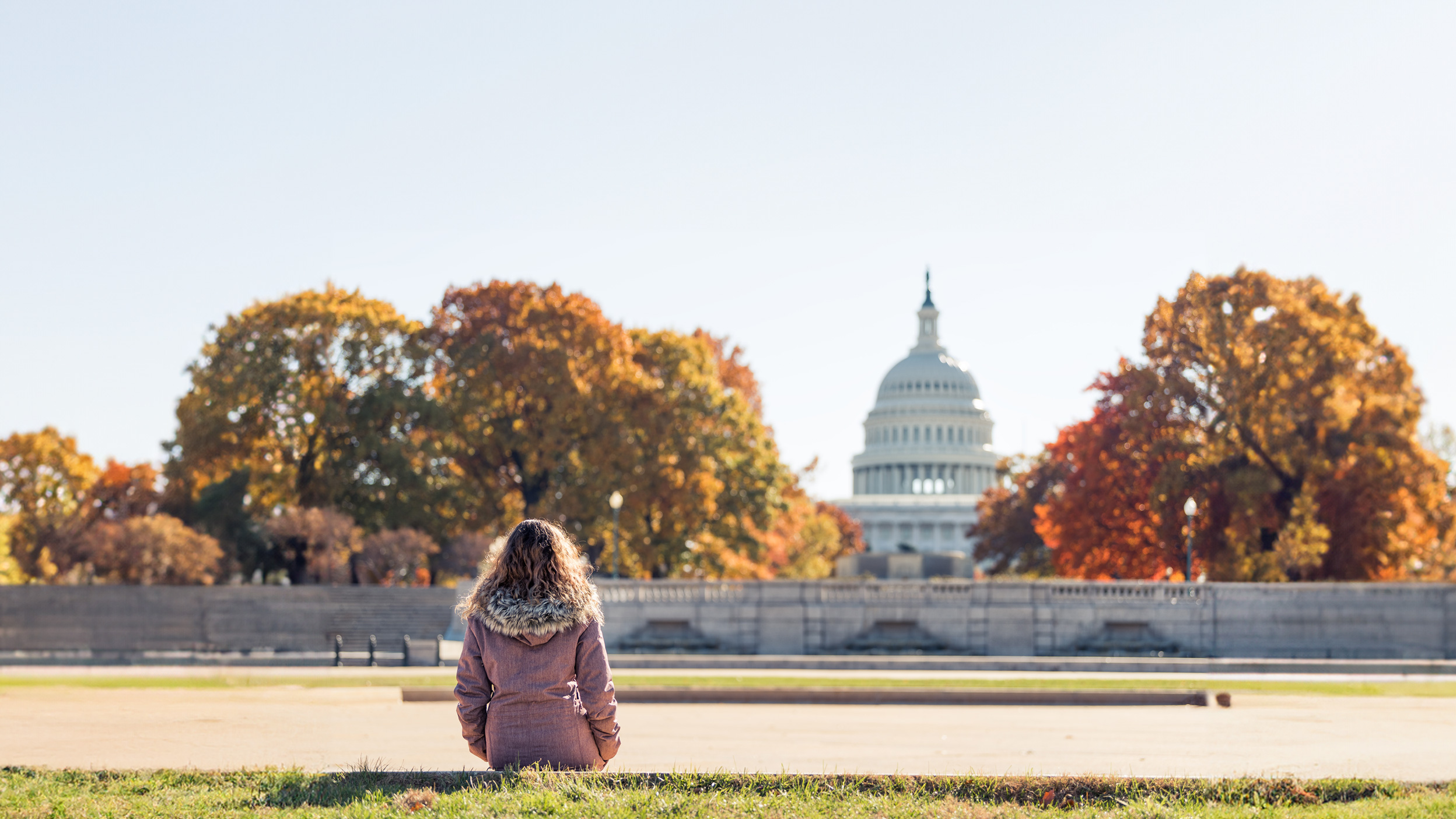 Woman looking at washington capitol building from afar