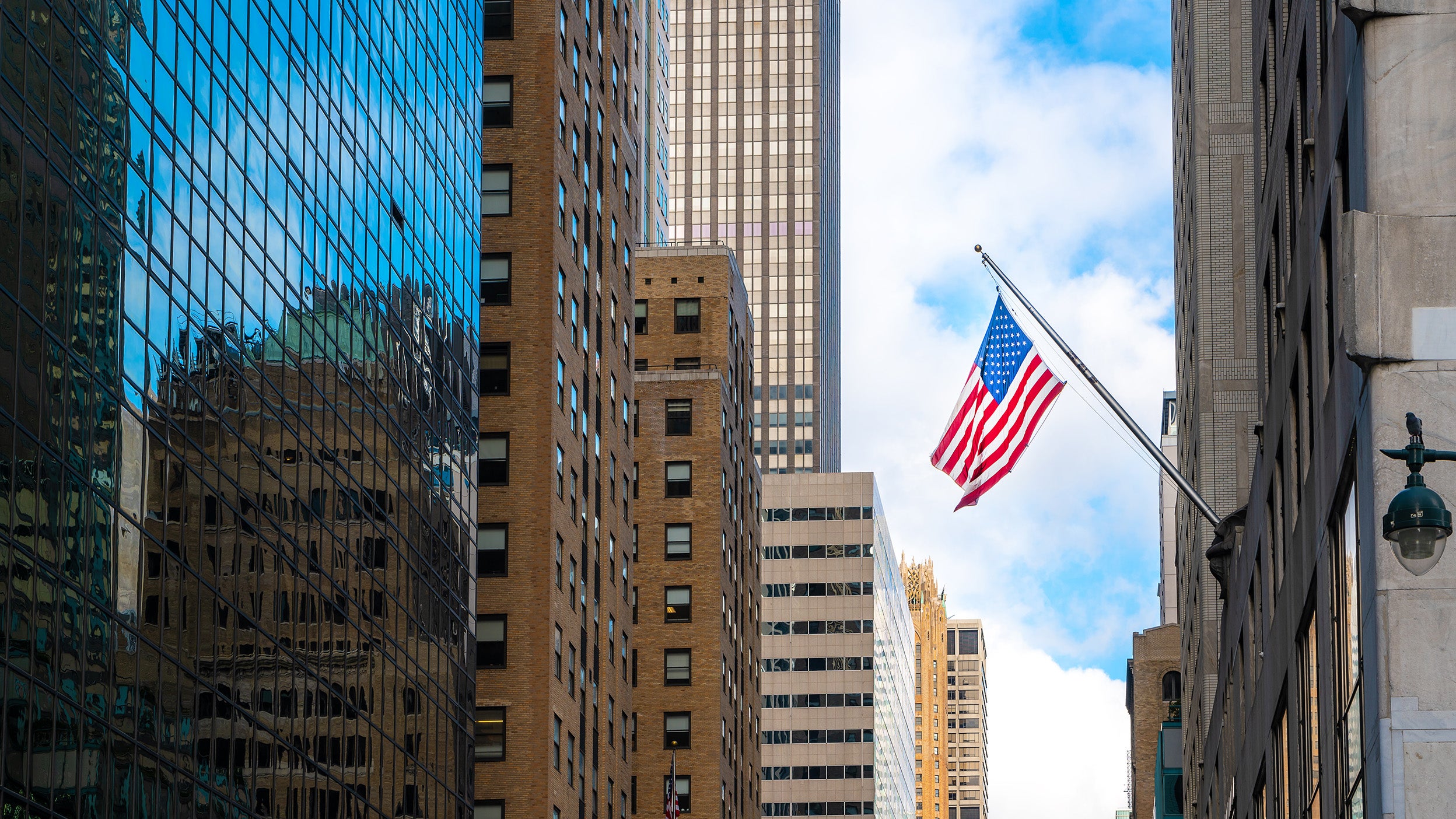 American flag hanging in between high-rise office buildings