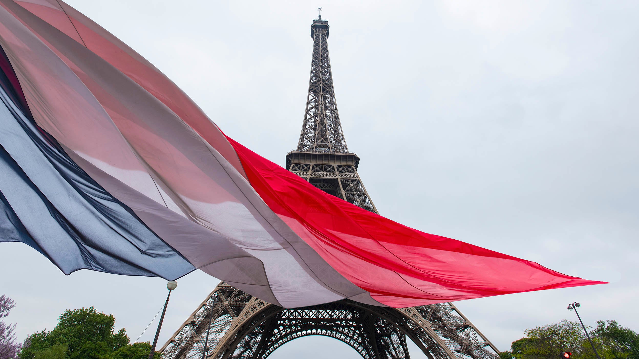 Eiffel tower with the French flag in the foreground