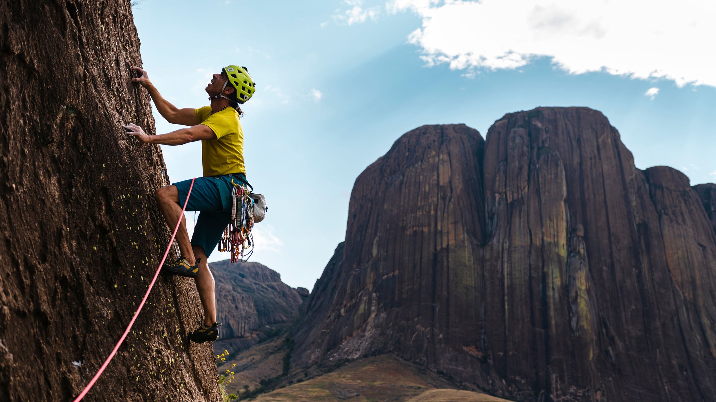 Man climbing a mountain with a grapple hook