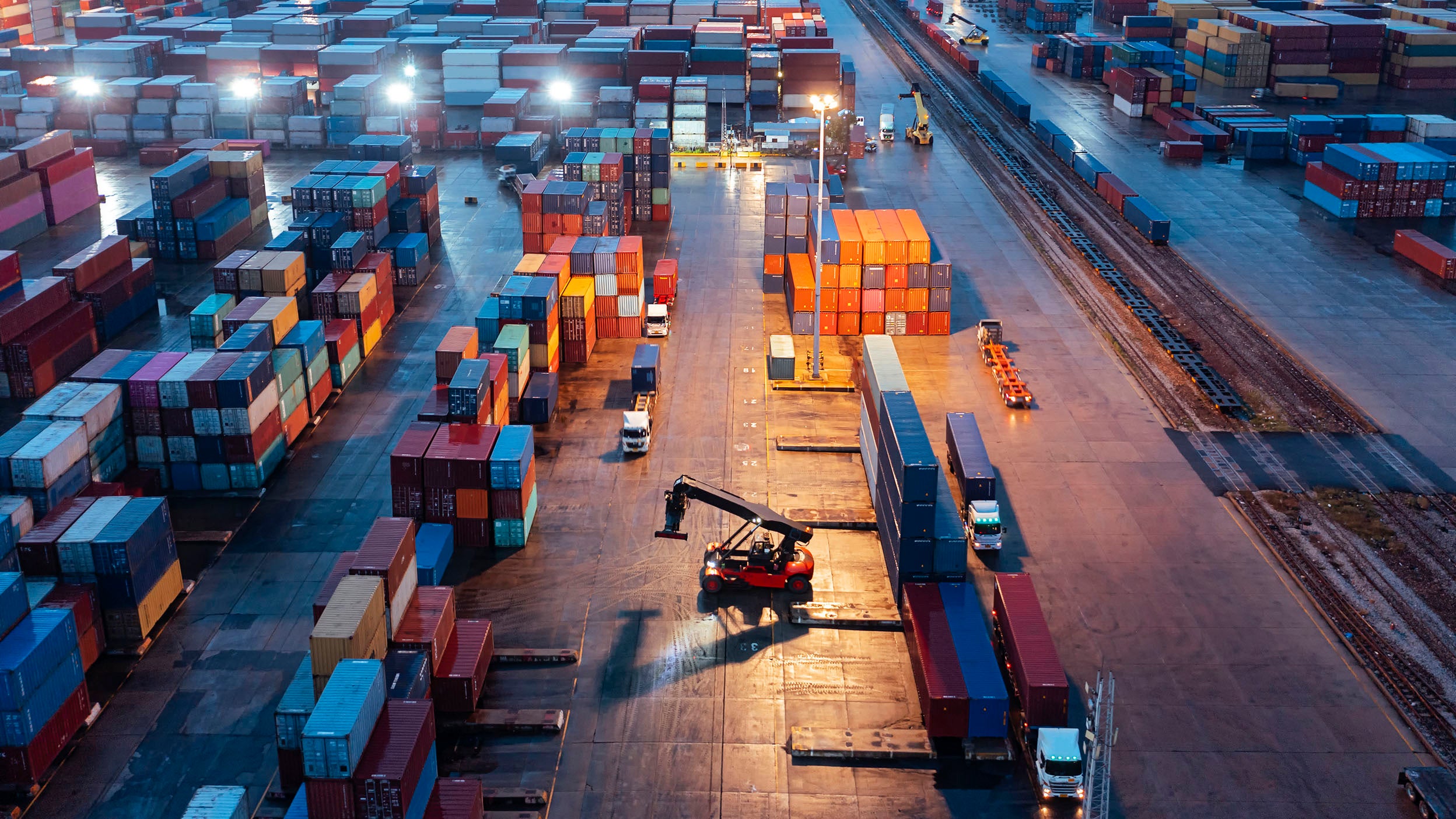 Aerial view of a forklift handling a container load at a container warehouse.