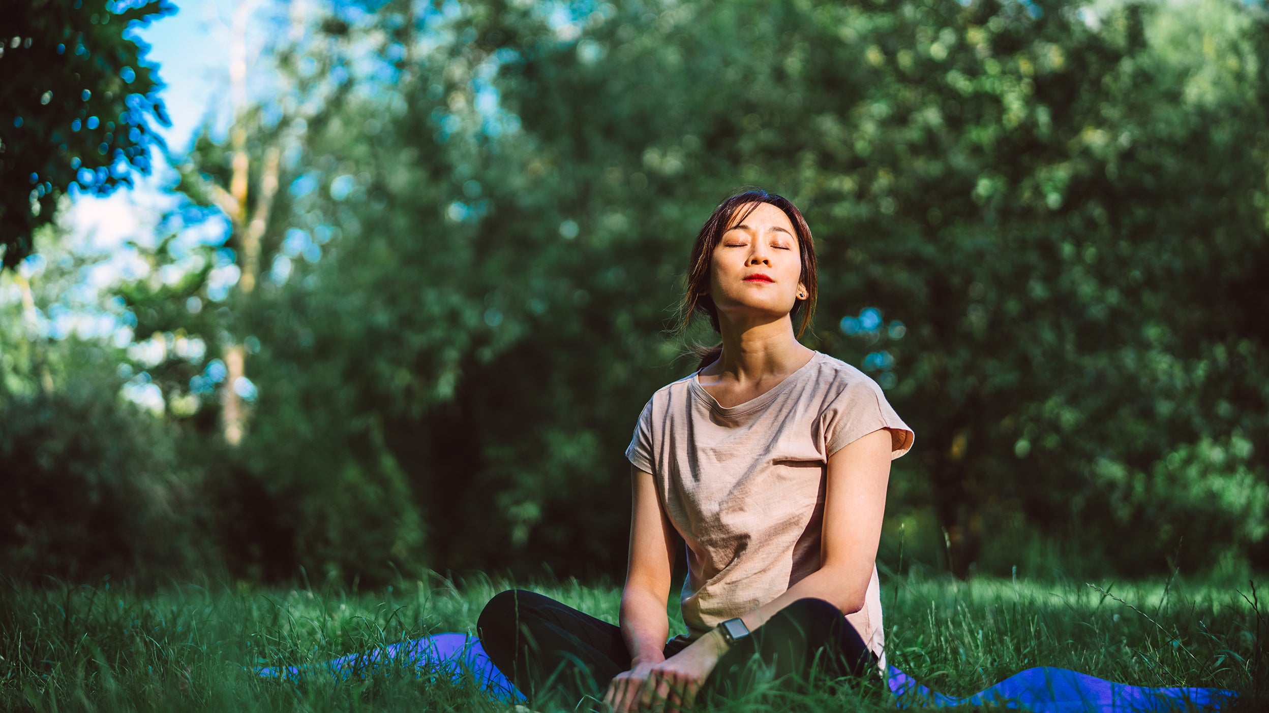 Young Asian woman practicing mindfulness and yoga in nature