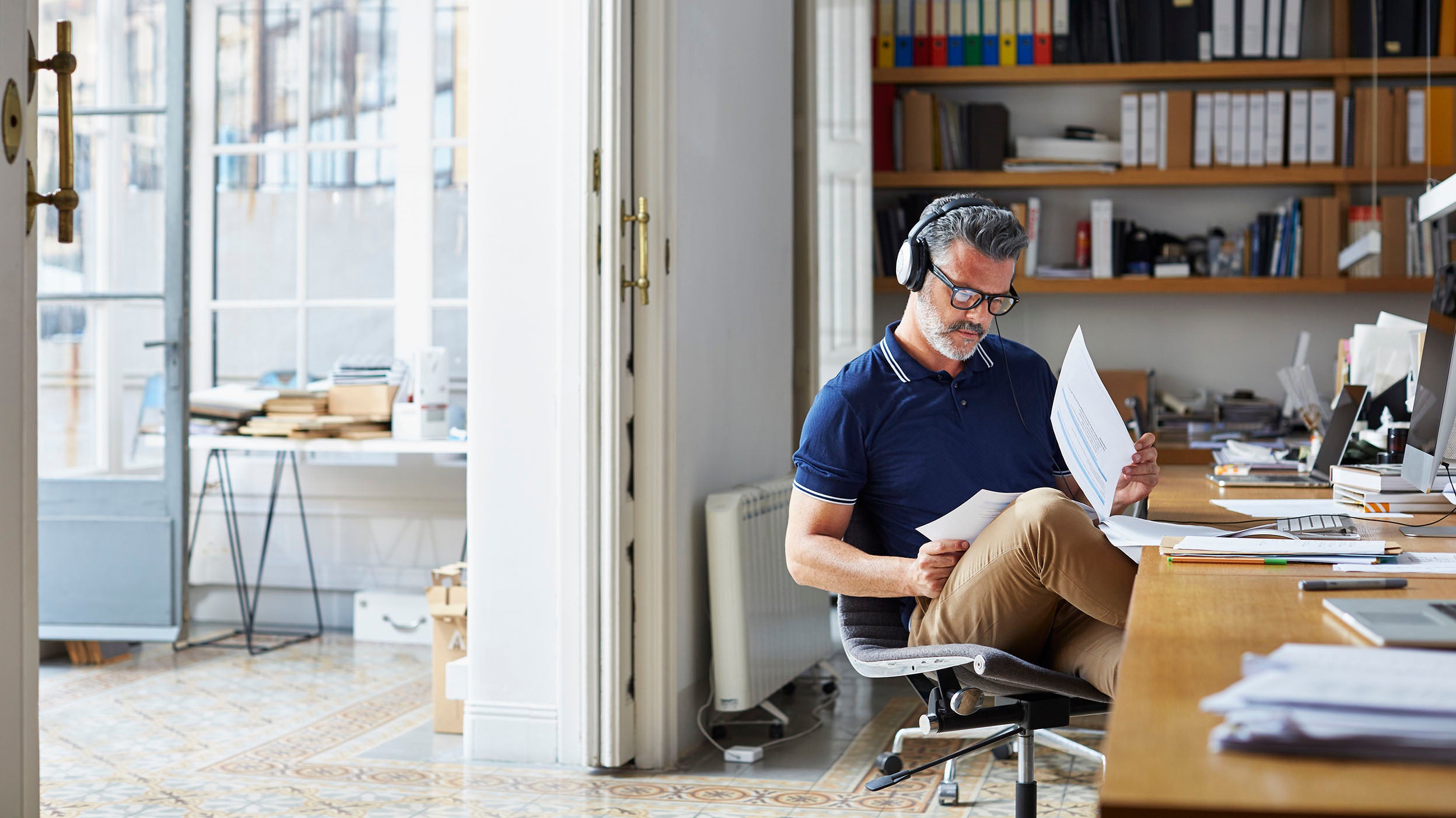 A person reading documents at his desk