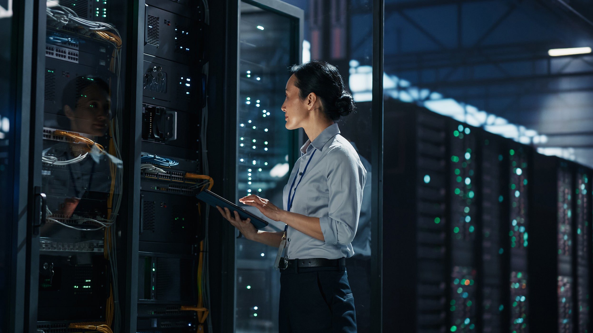 Person inspecting server racks in a data center