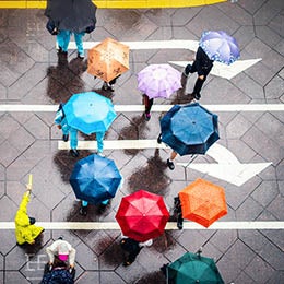 Aerial%20view%20of%20walking%20people%20using%20colorful%20umbrellas%20in%20rain
