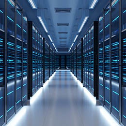 %20A%20corridor%20between%20rows%20of%20illuminated%20server%20racks%20in%20a%20data%20center