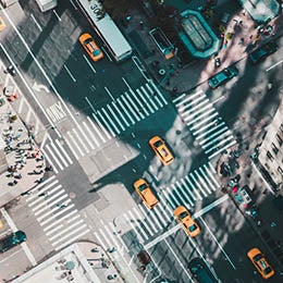 Aerial%20view%20of%20a%20bustling%20intersection%20with%20business%20people%20heading%20to%20meetings,%20surrounded%20by%20tall%20urban%20buildings%20casting%20long%20shadows.