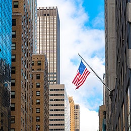 American%20flag%20hanging%20in%20between%20high-rise%20office%20buildings