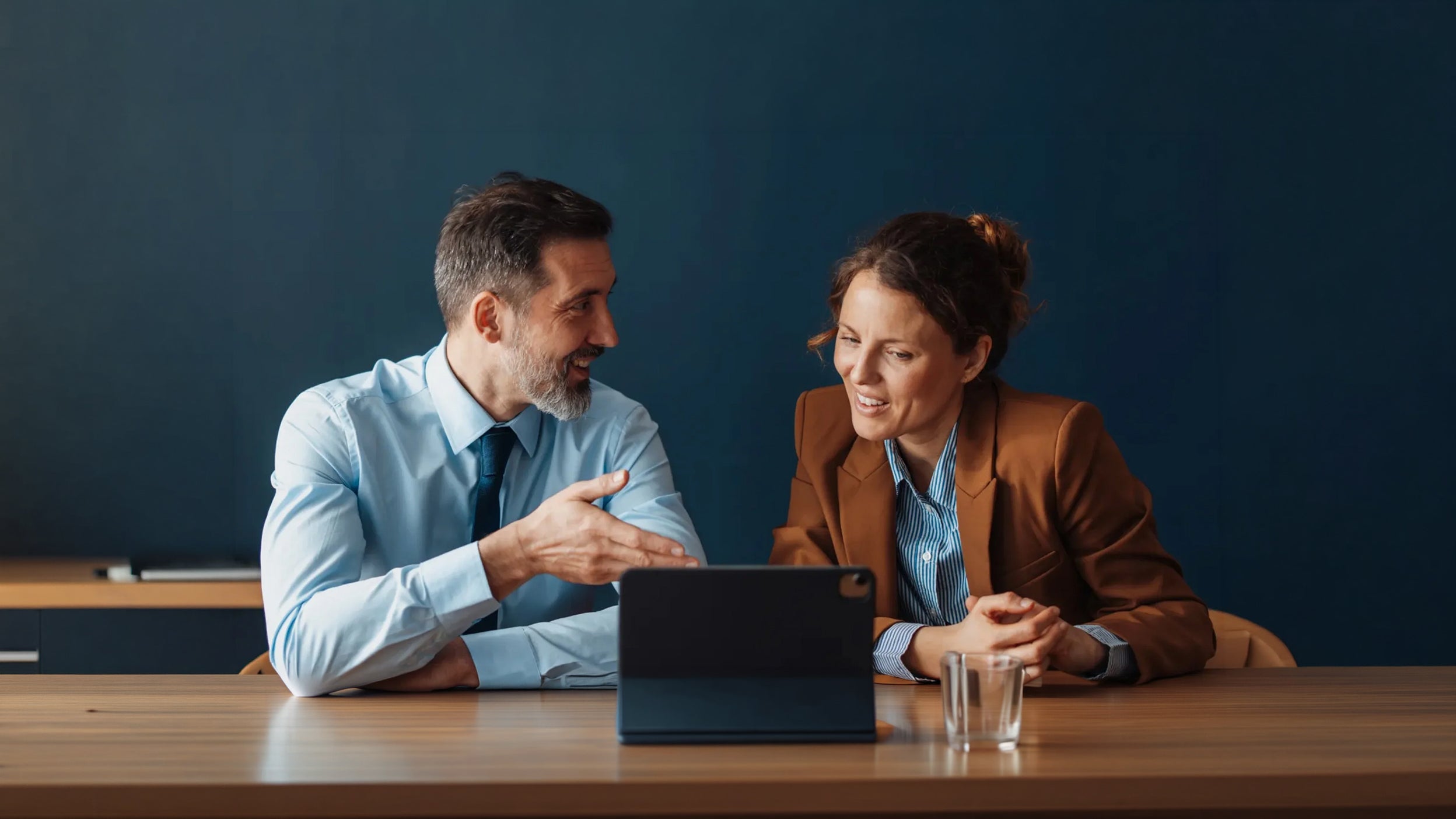 Two people reviewing information on a tablet