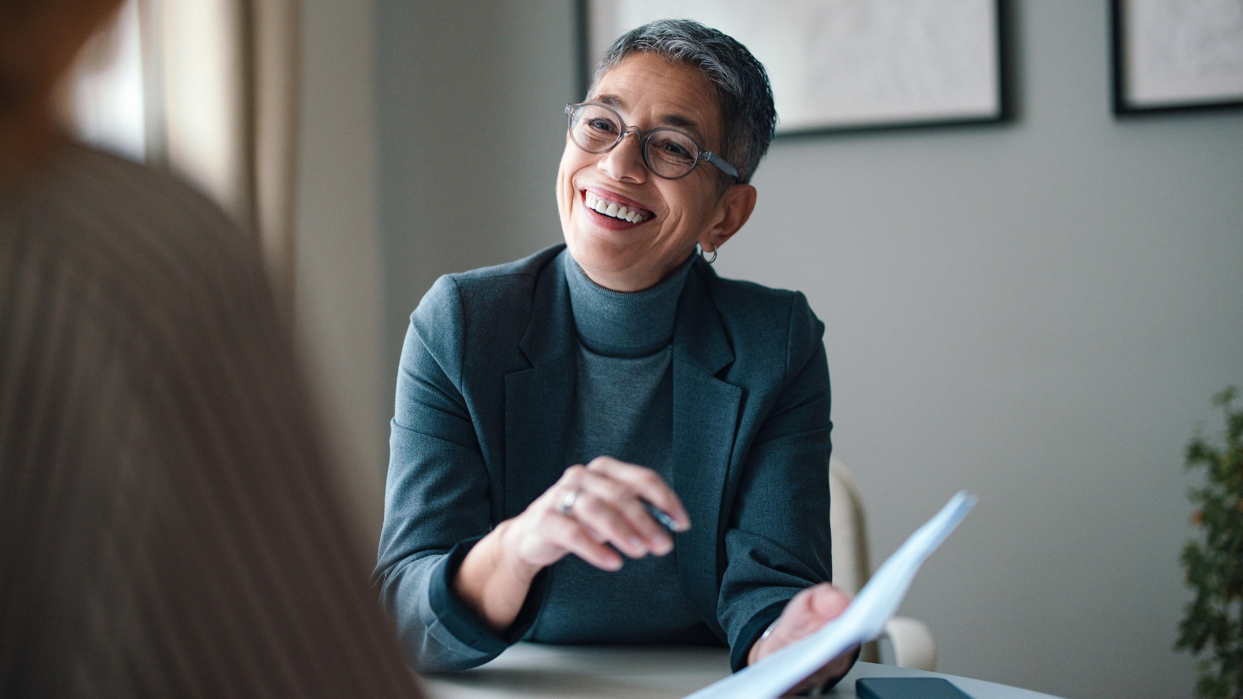 Person smiling and reviewing a document