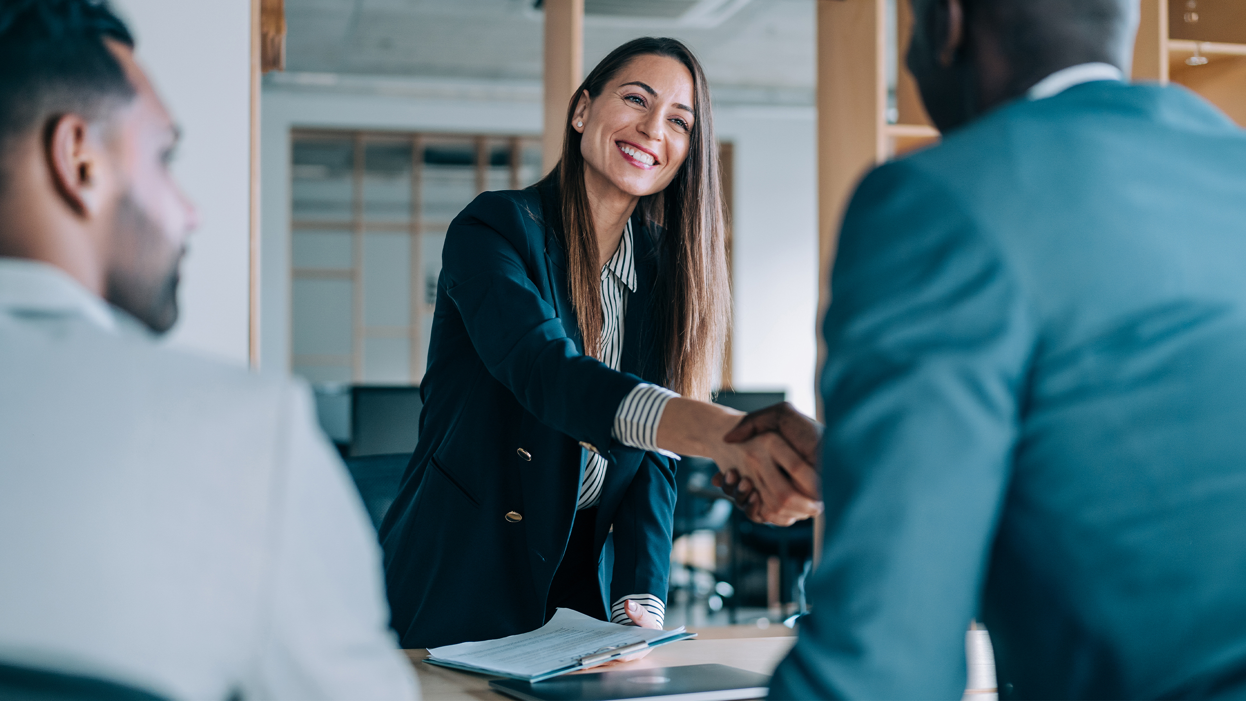 Business handshake across a desk.