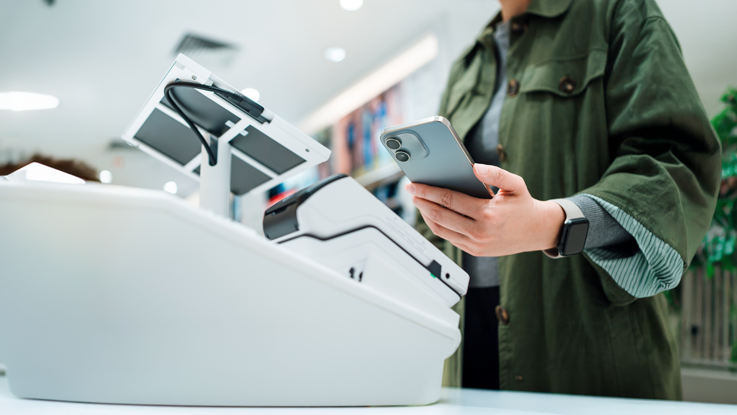 Person using phone to pay at checkout