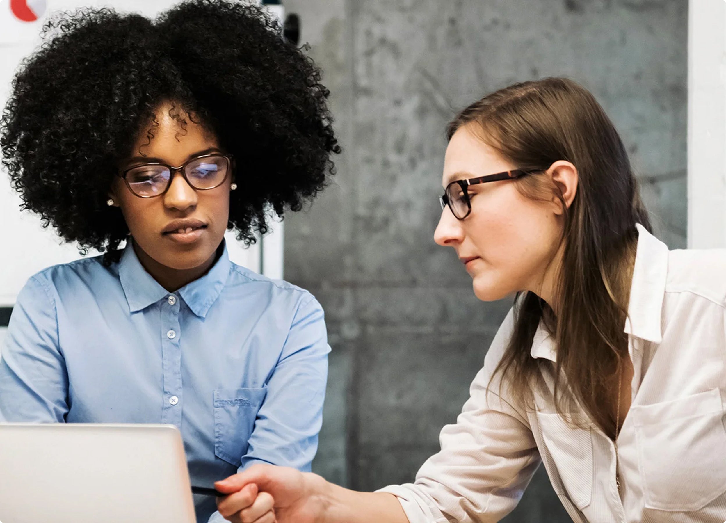 Two people reviewing information in a laptop