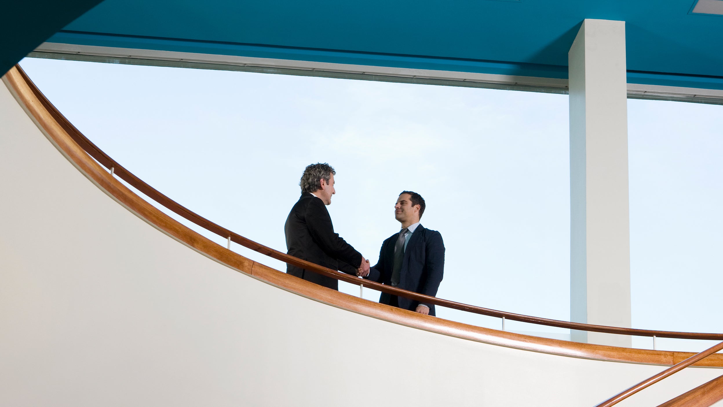 Businessmen shaking hands on stairway