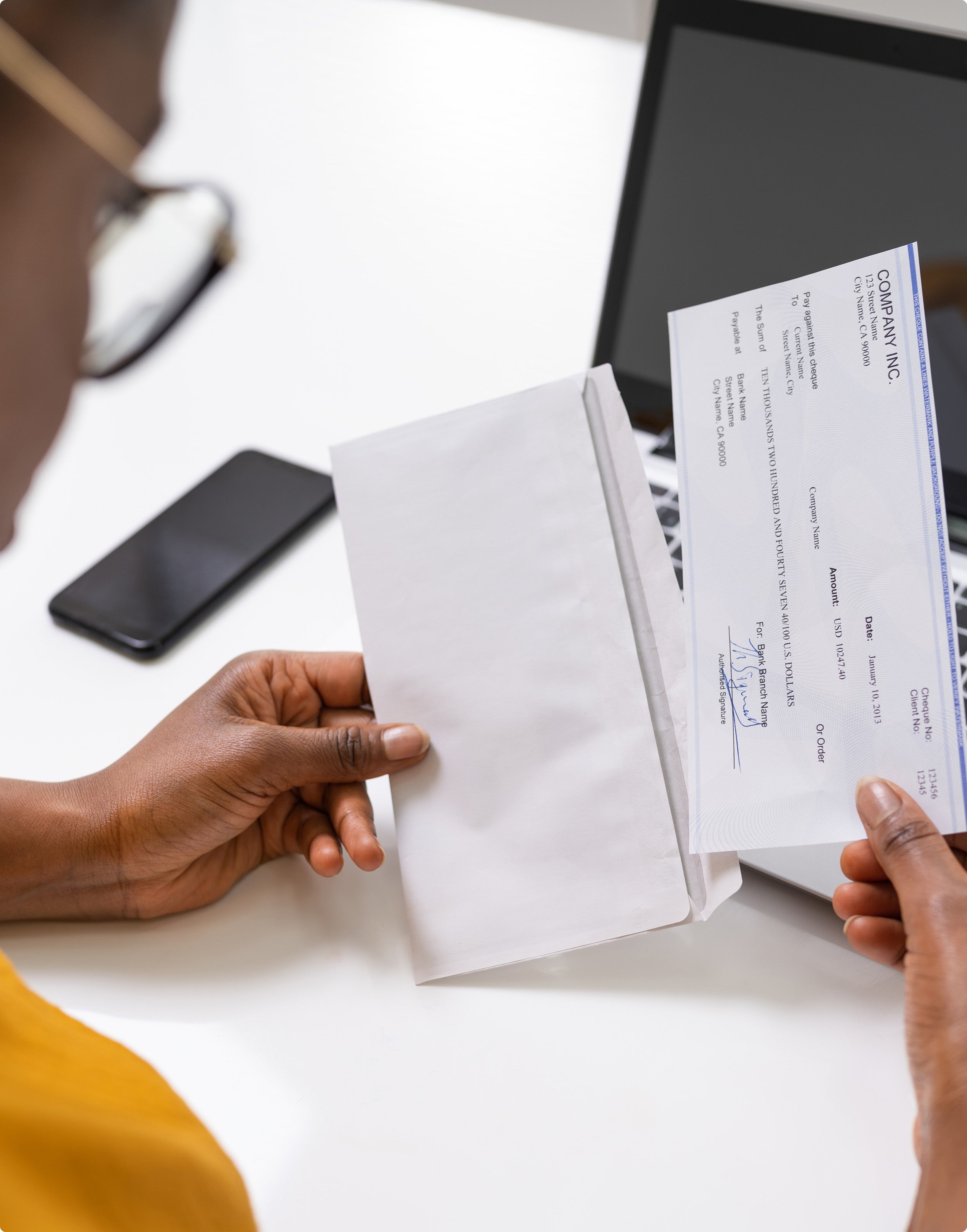 Women opening an envelop with a check