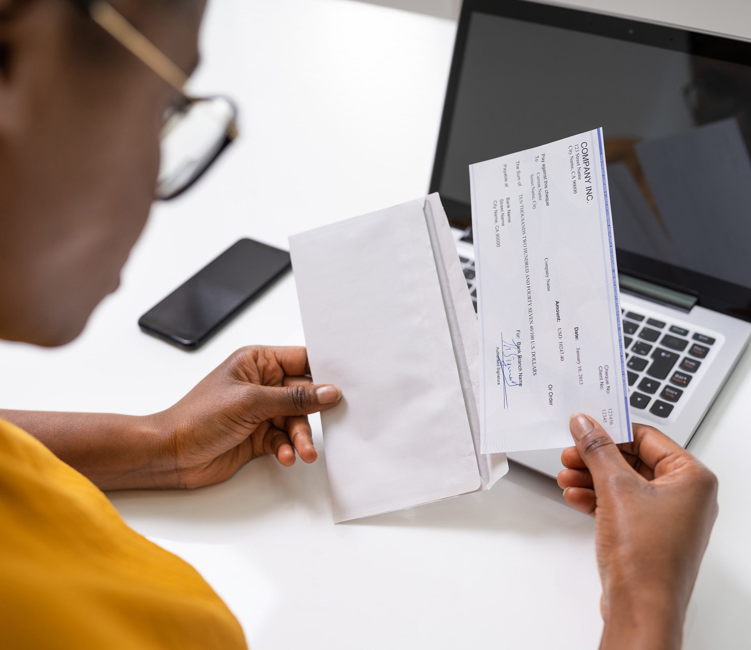 Women opening an envelop with a check