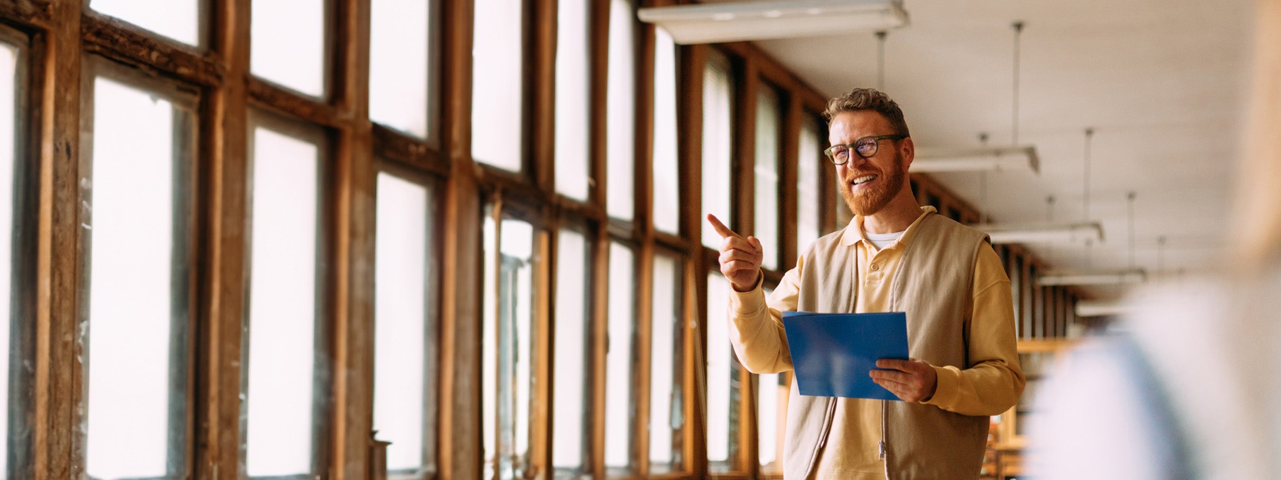 Man presenting to a group in a bright workspace.